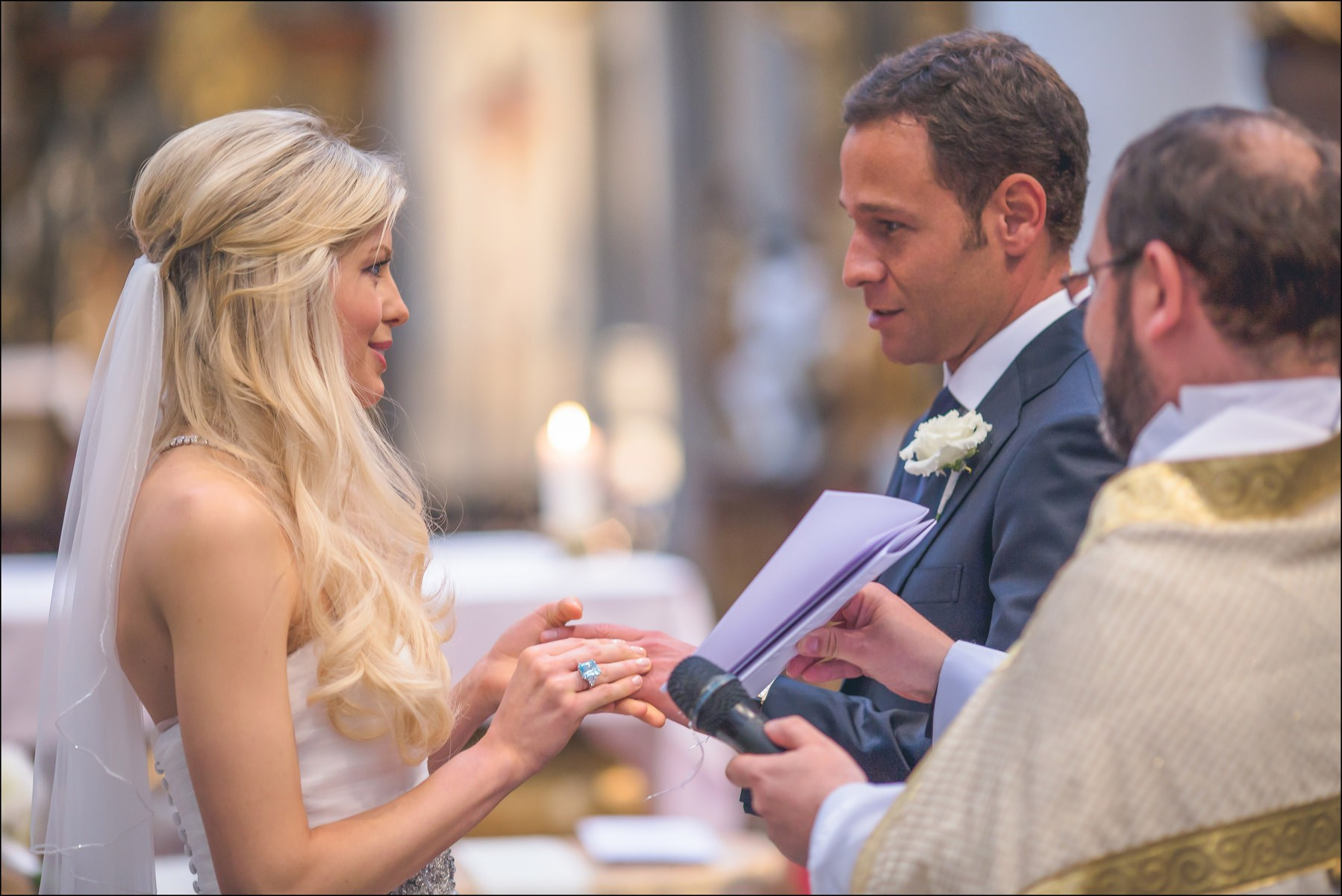 Ring exchange moment with priest at St. Thomas Church Prague ceremony