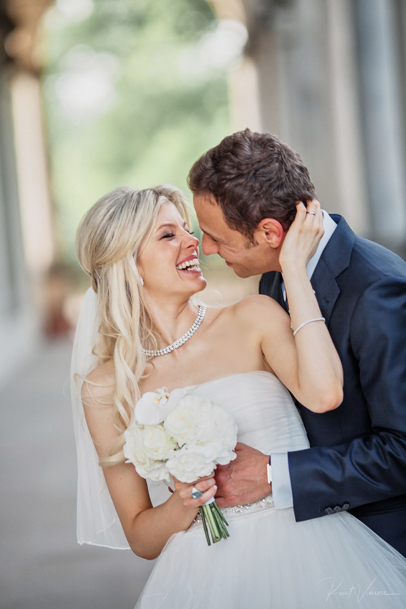 Candid laughing kiss between newlyweds at Belvedere Prague
