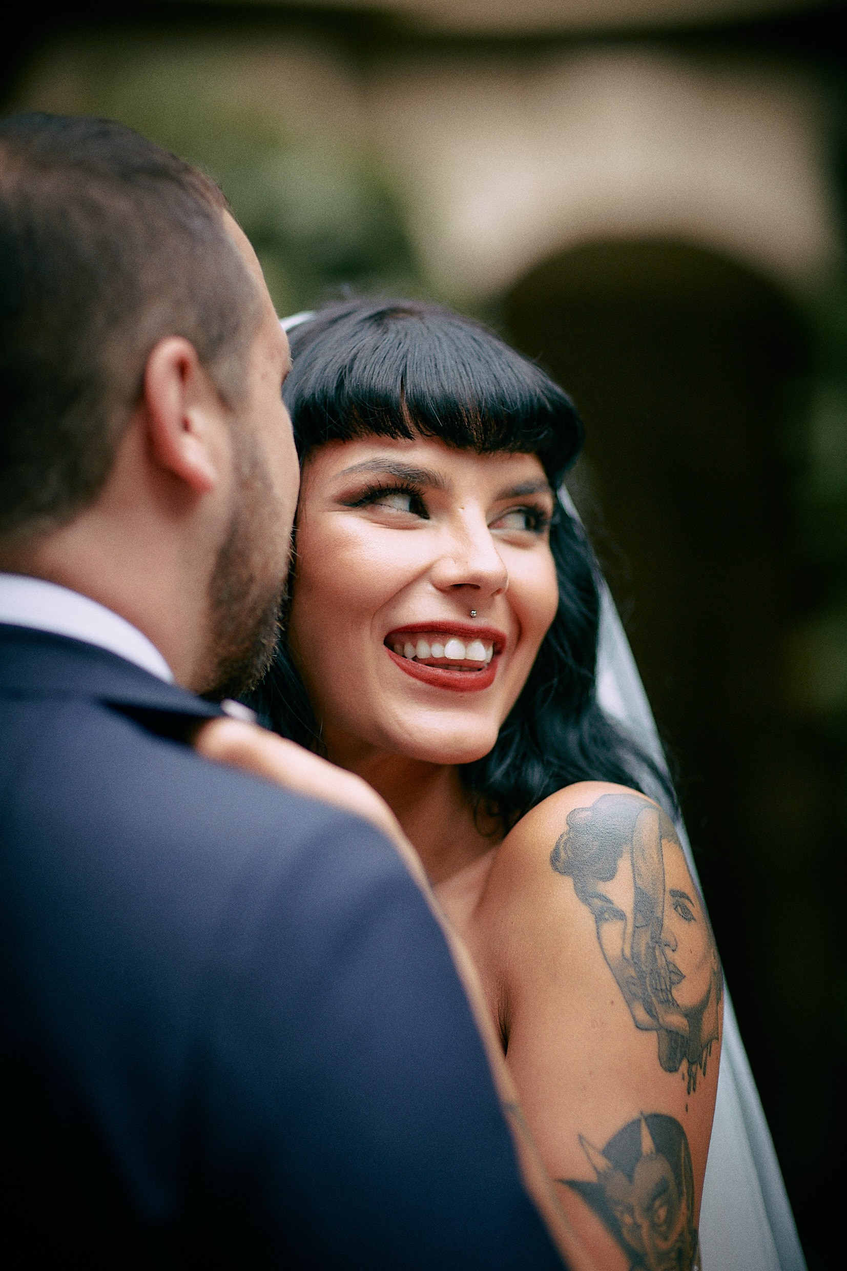 Newlyweds embracing in lush romantic Grebovka Park artificial grotto.