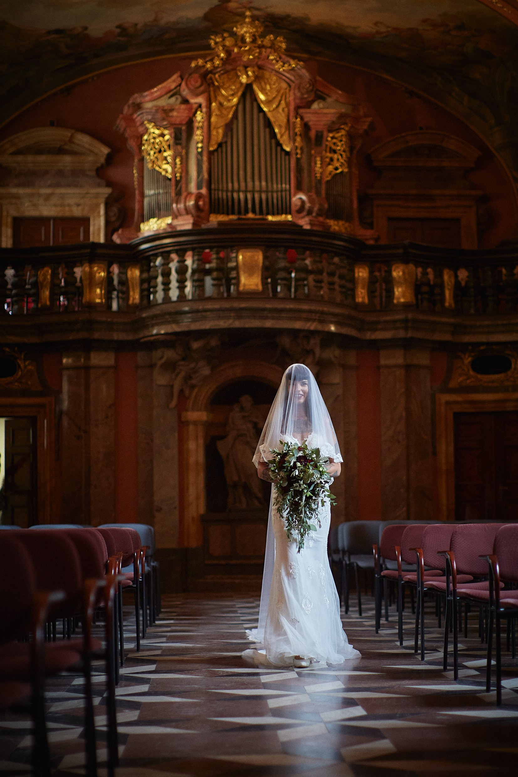 Radiant tattooed bride smiling during processional entrance.