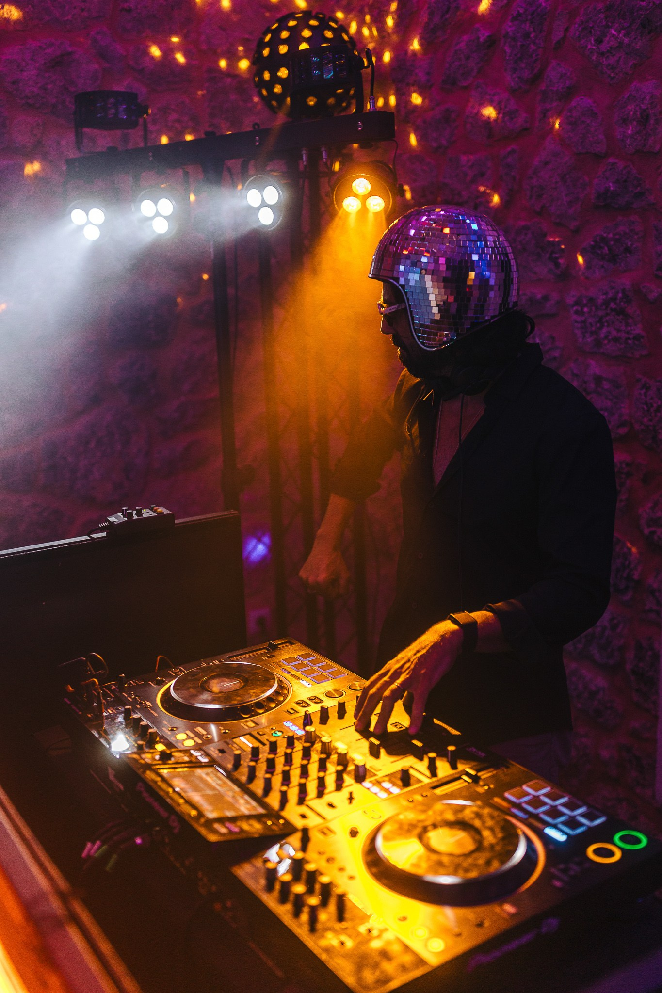 DJ wearing a disco ball helmet performing at a Mallorca wedding reception