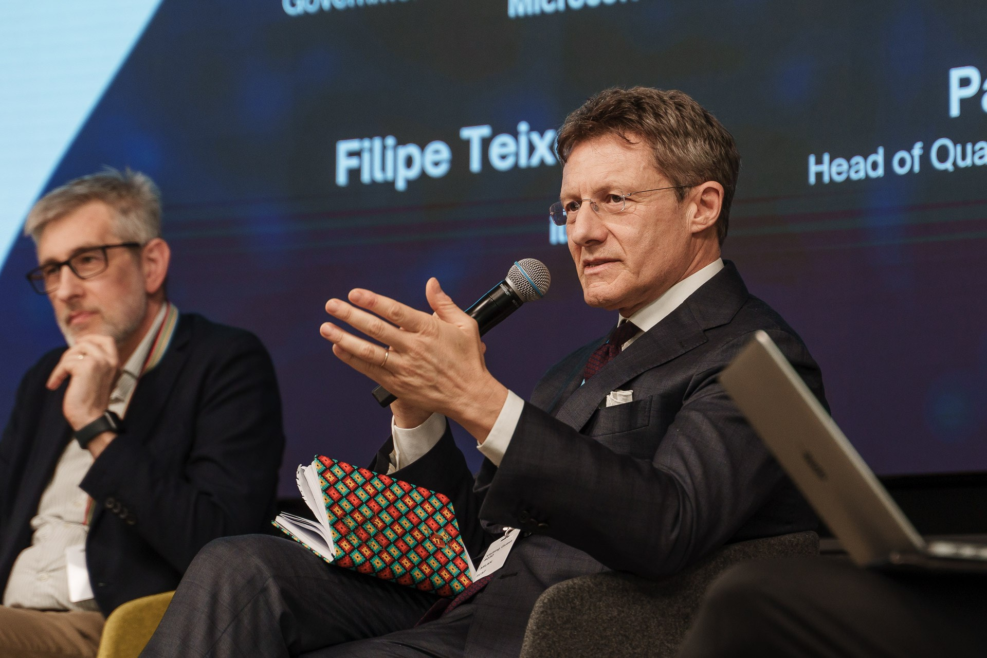 Business panel discussion photographed at a corporate event in Milan