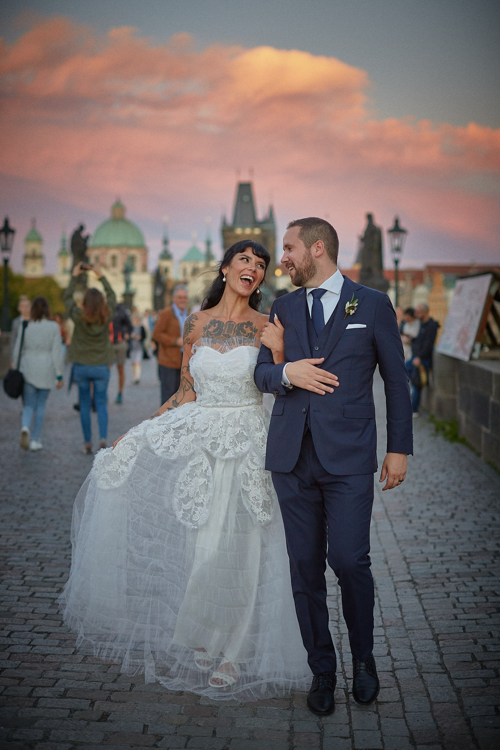 Couple walking across the Charles Bridge at dusk..