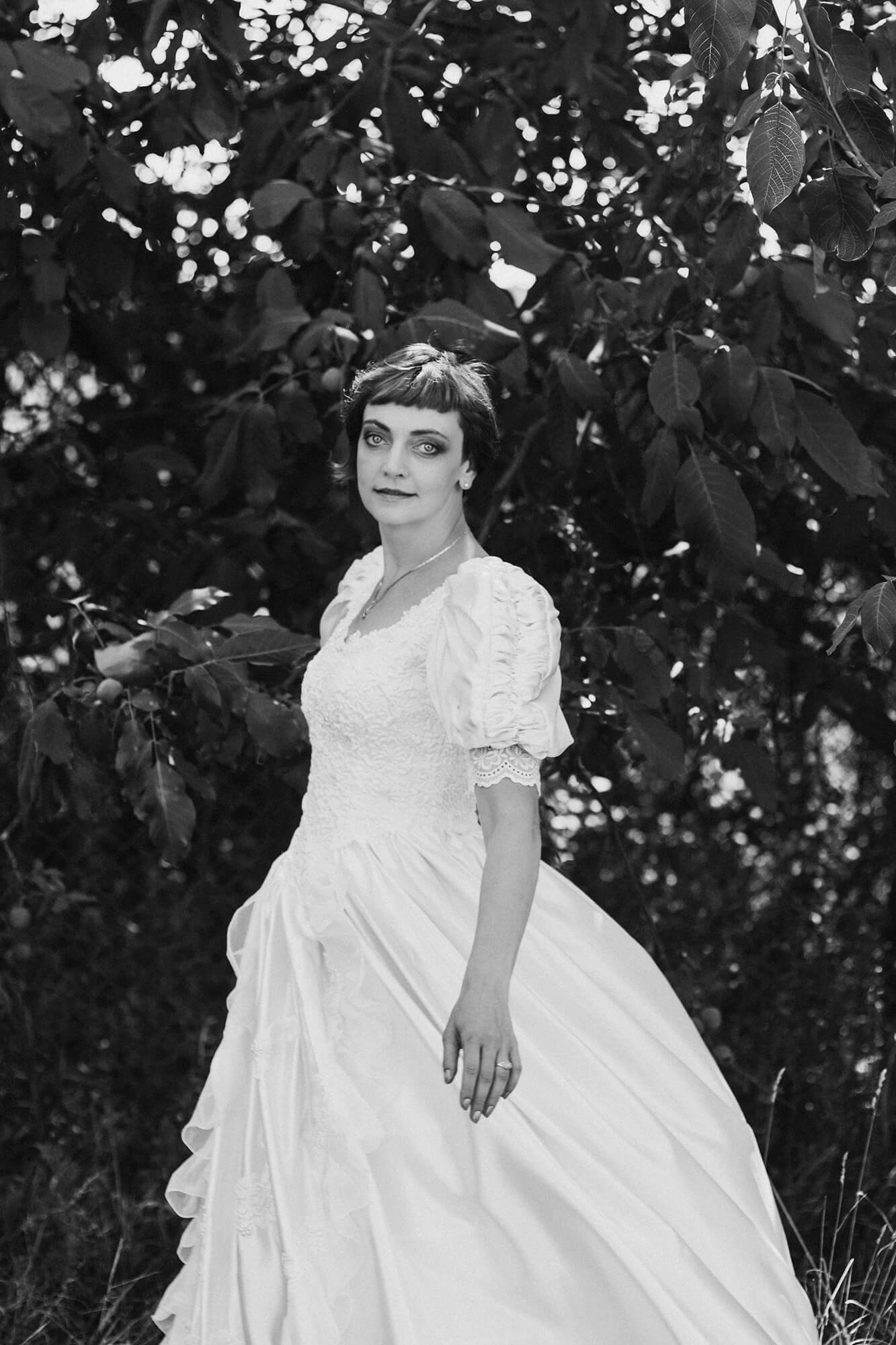 A bride in a flowing lace gown posing against the backdrop of a dreamy Yarra Valley vineyard, exuding timeless elegance in Melbourne wedding photography.