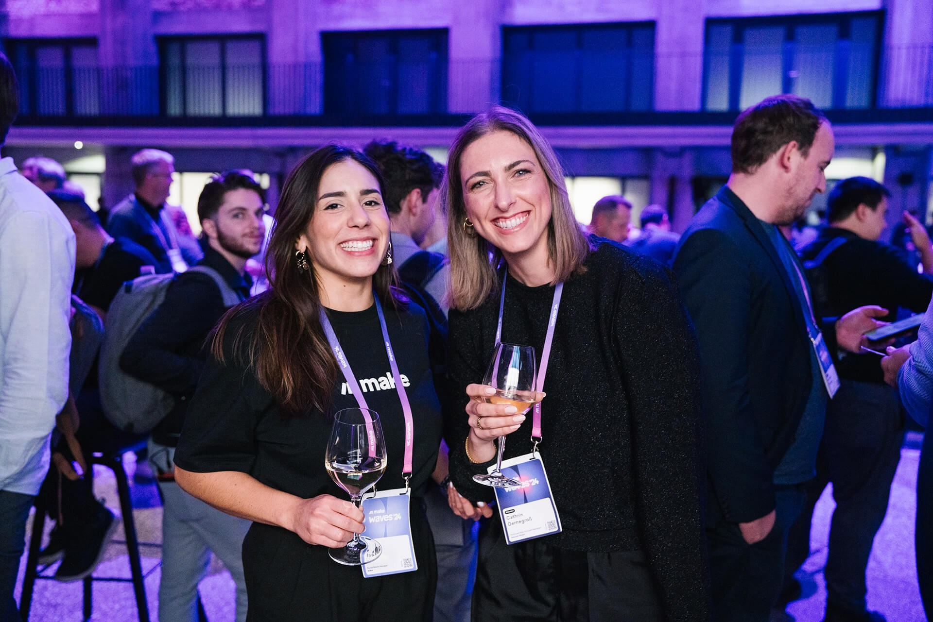 Zwei Frauen posieren gemeinsam bei einem abendlichen Business-Empfang