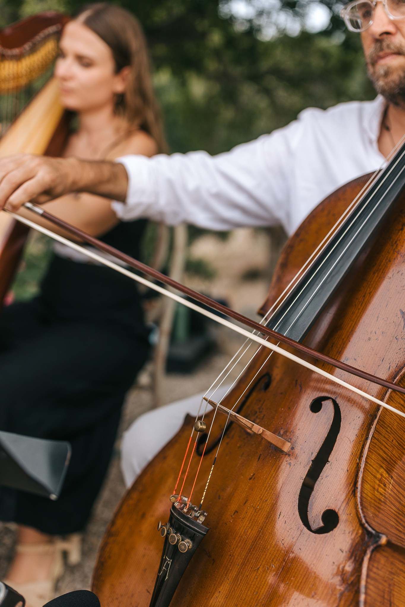Close-up of a cellist and harpist performing at Jessie and Amish's Mallorca wedding ceremony