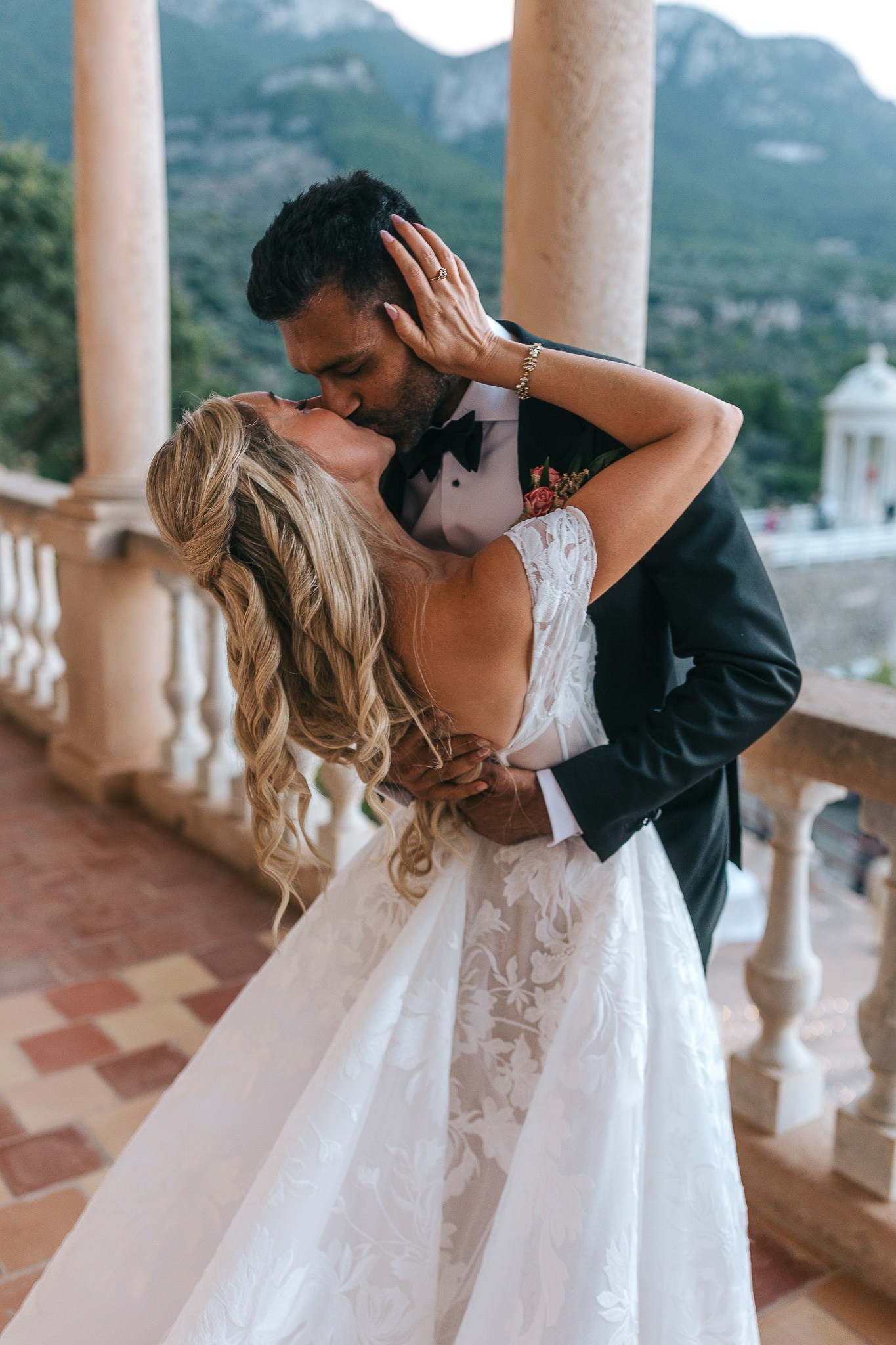 Newlyweds kissing on the balcony after their personalized wedding ceremony at Son Marroig
