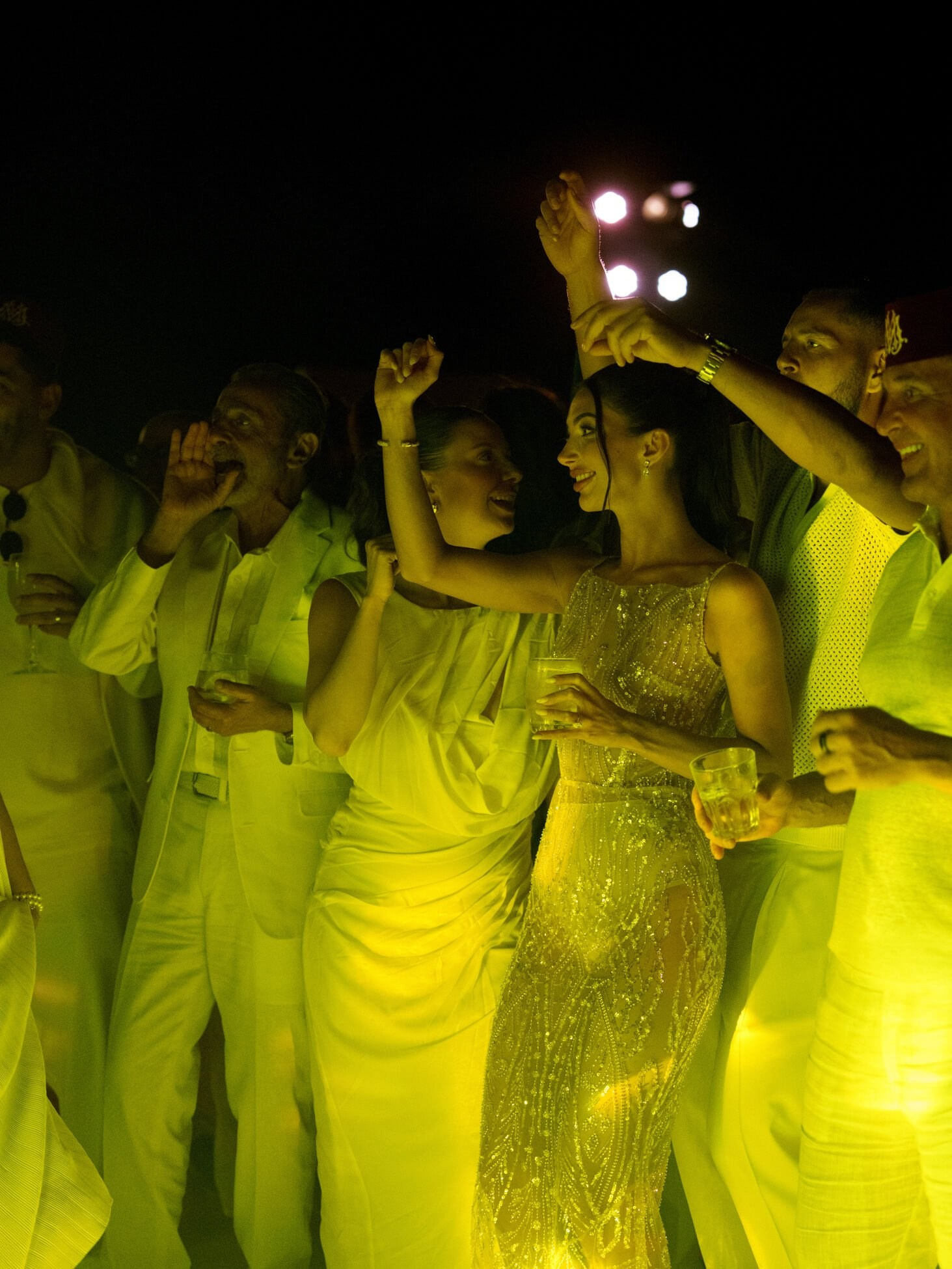 Guests dancing with drinks at destination desert wedding party