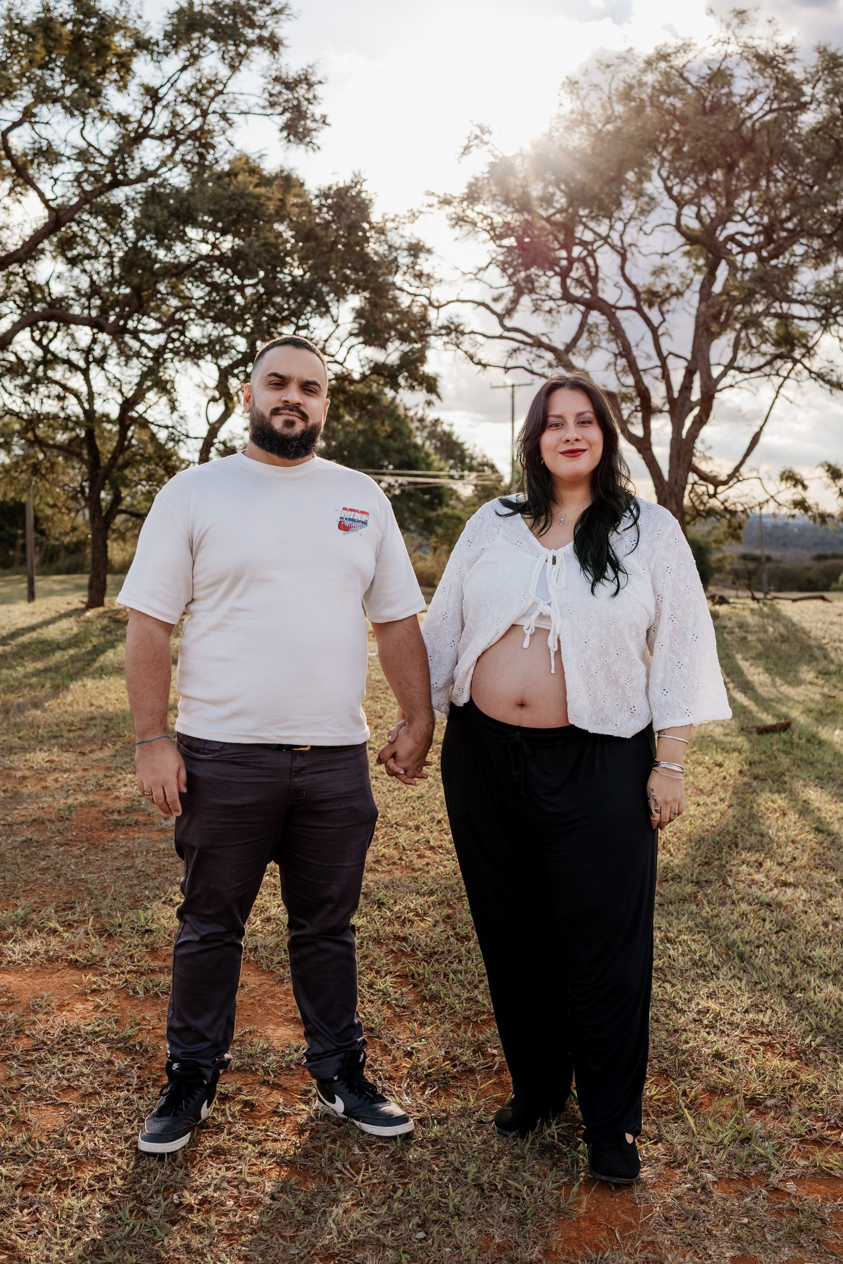 Casal caminha com calma em meio ao verde.