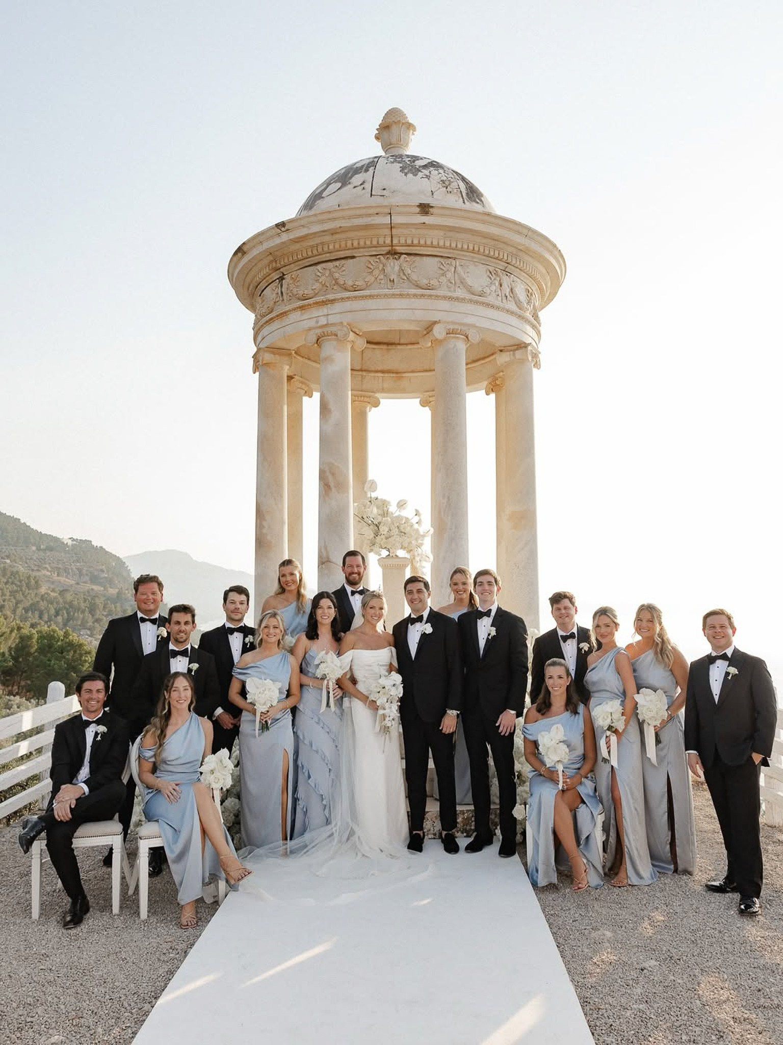 Wedding party portrait with bridesmaids in dusty blue gowns at the Son Marroig temple, Mallorca