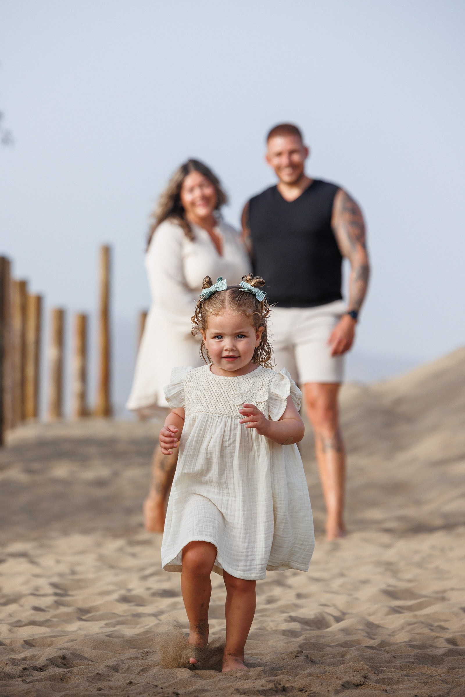Toddler running ahead of her parents during a family photoshoot in the Maspalomas dunes, Gran Canaria