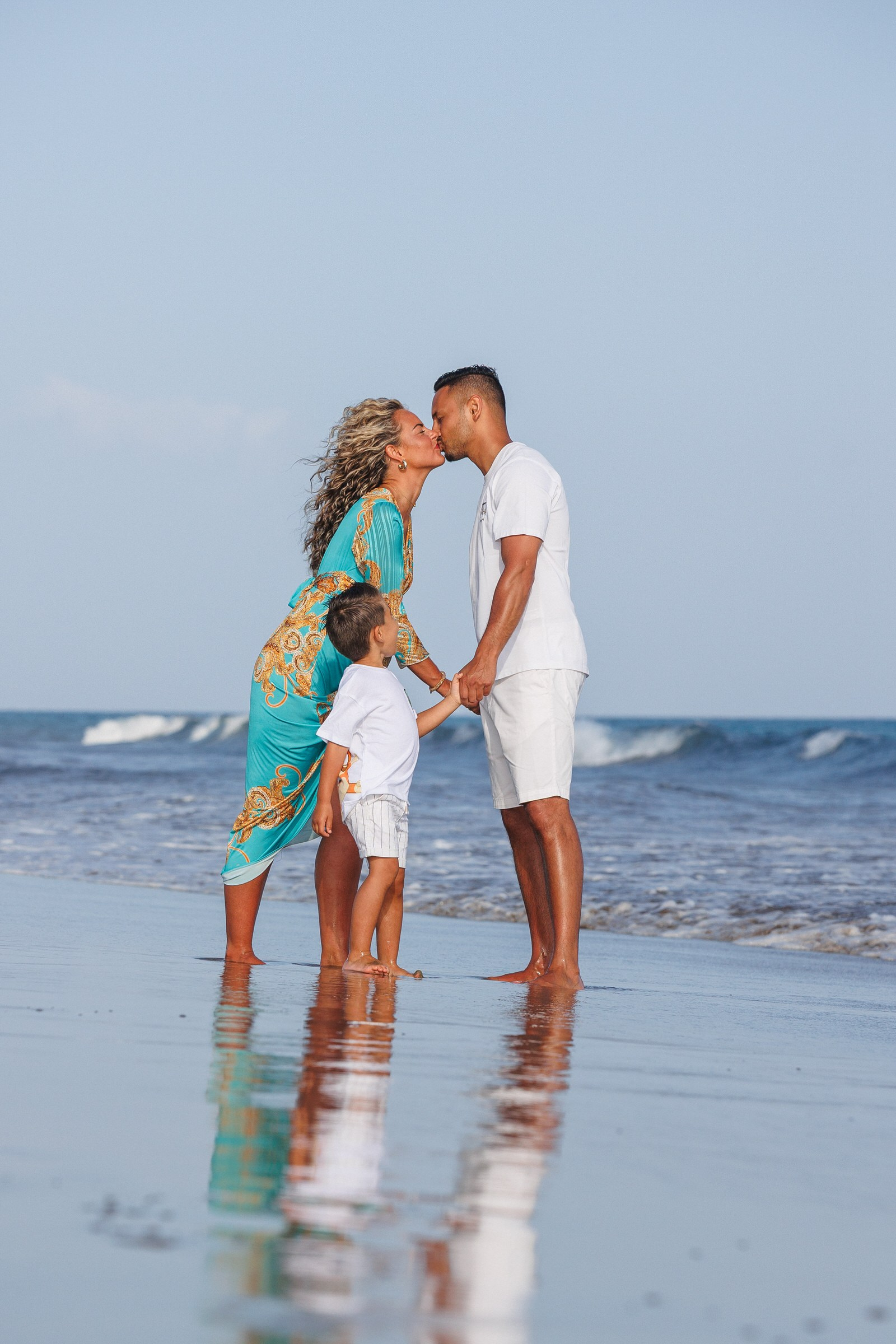 Couple kissing in the ocean with their child on the beach, Gran Canaria