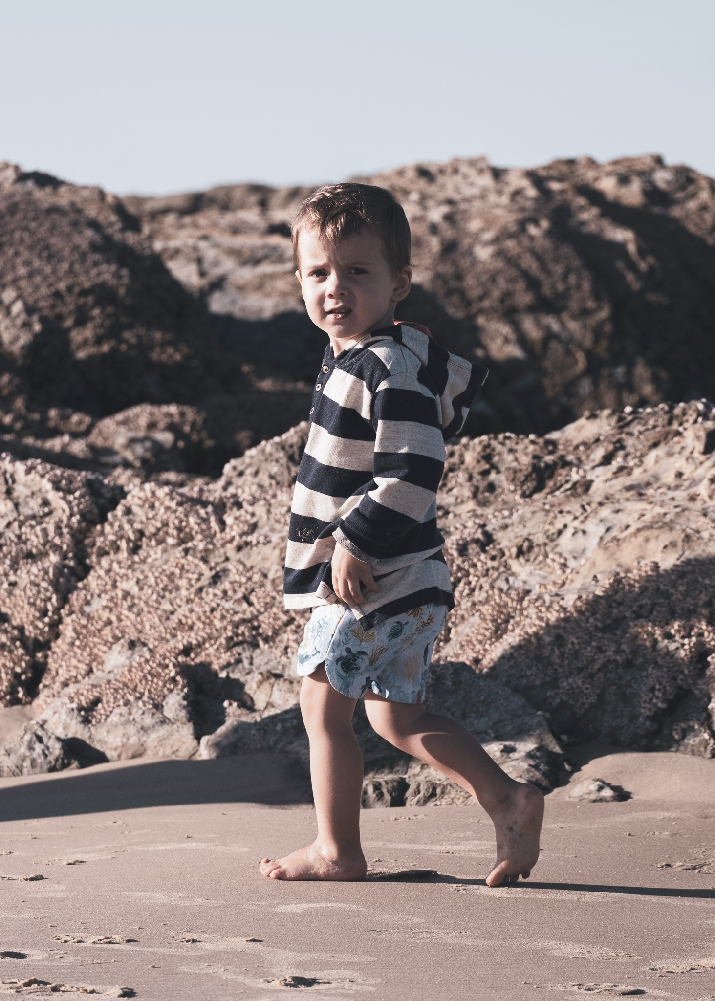 Happy family walking barefoot on the beach in Brisbane, candid family photography.