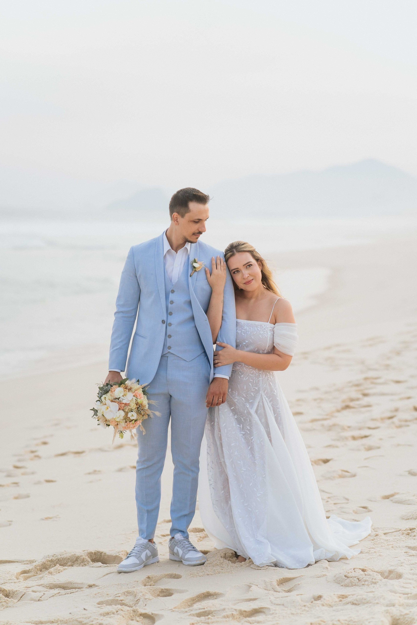 Noivos caminhando na areia durante casamento na praia no Rio de Janeiro