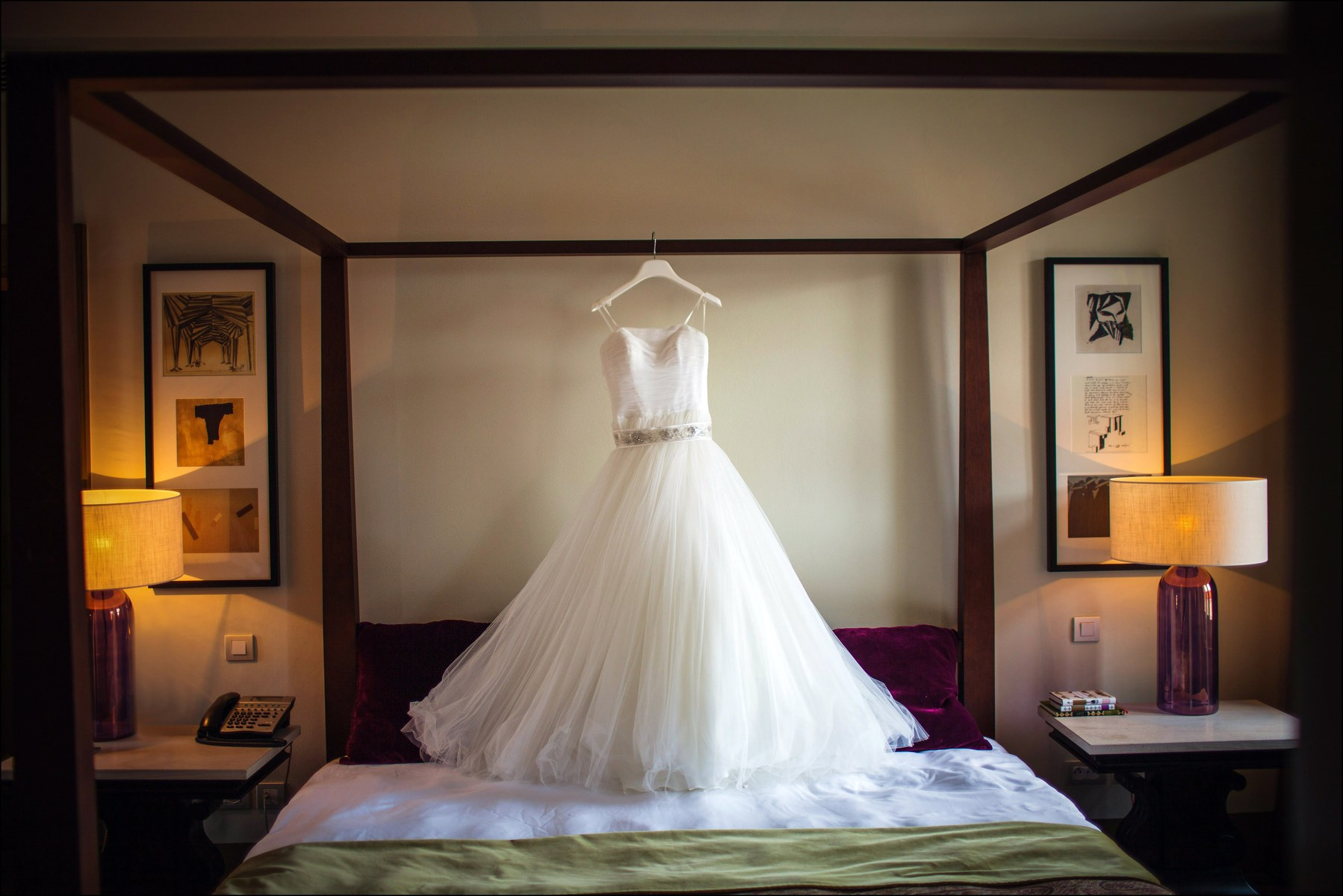 Bride's elegant wedding dress hanging in the luxurious suite at Augustine Hotel Prague during morning preparations