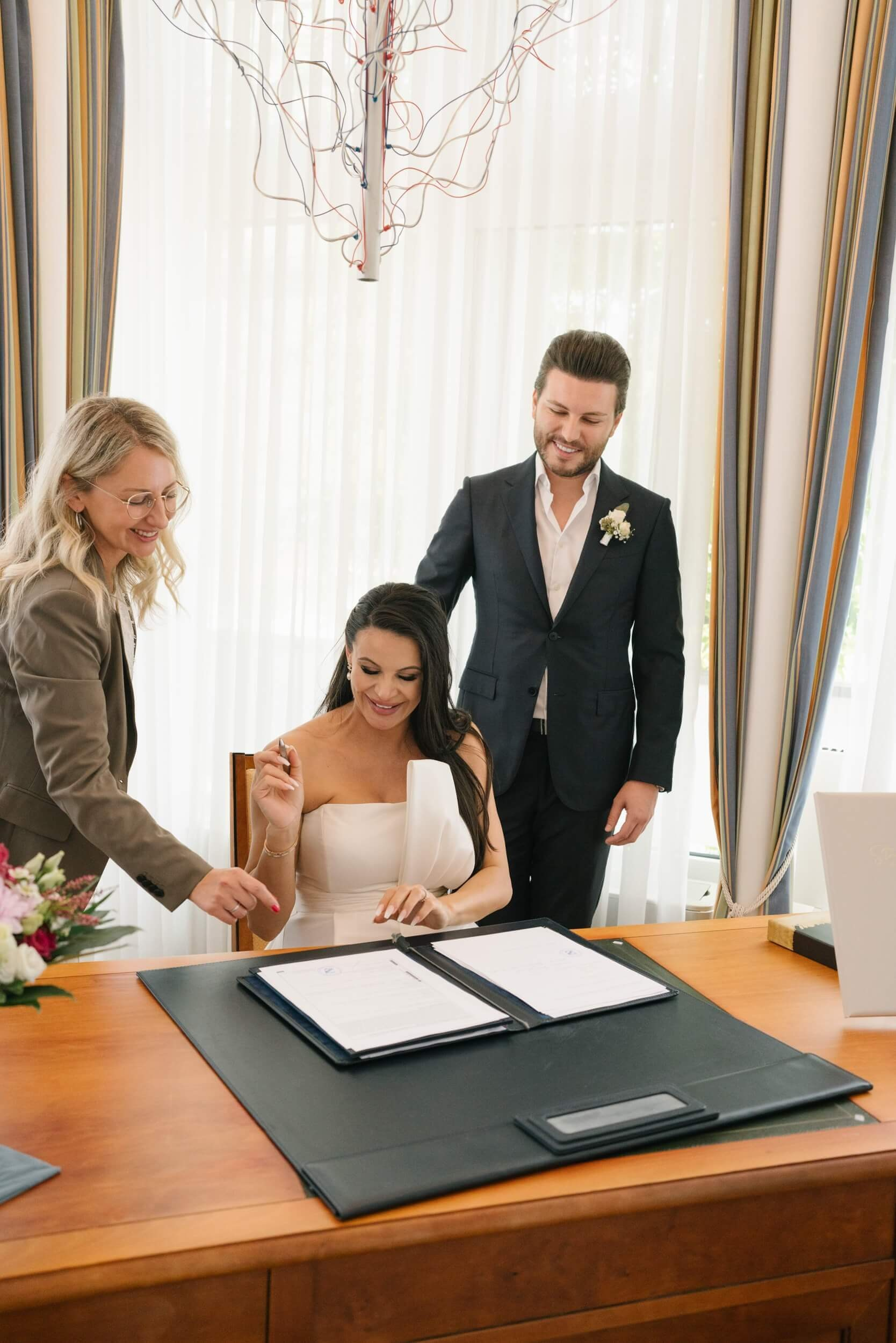 Bride signing marriage register at Standesamt Grünwald ceremony