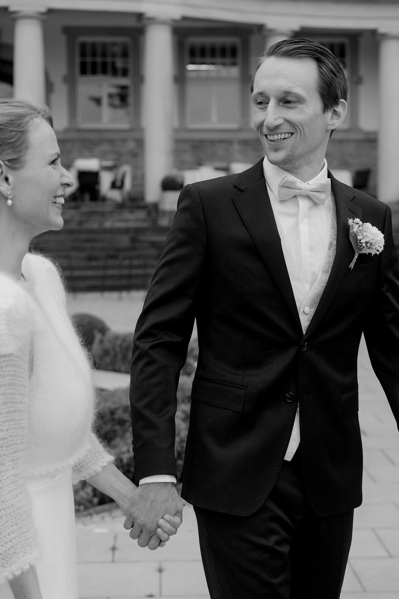 Black and white groom smiling, reception moment at Falkenstein Grand