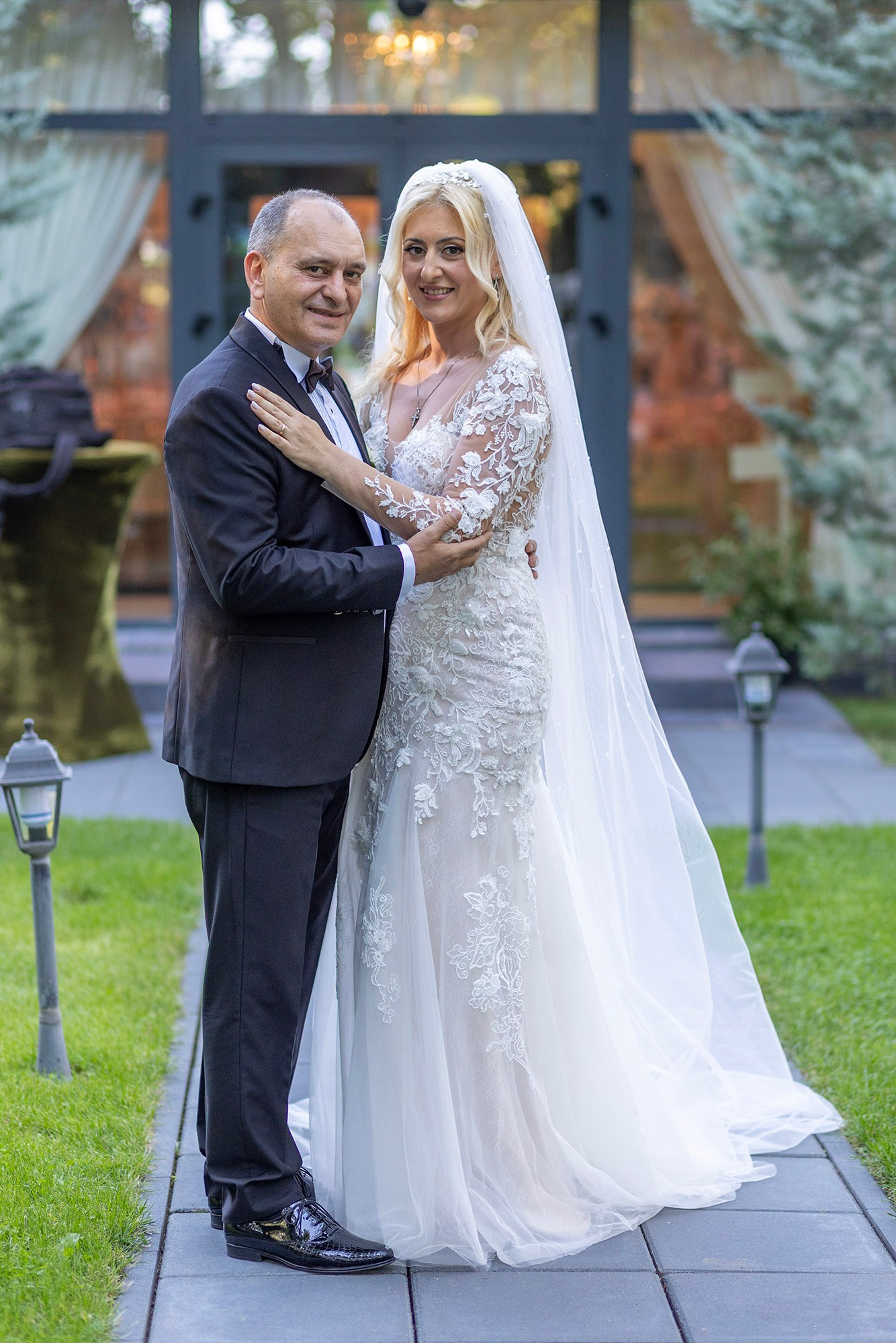 Portret de nuntă cu Marius și Daniela, mireasa stă cu palma pe umărul mirelui, se vede verigheta