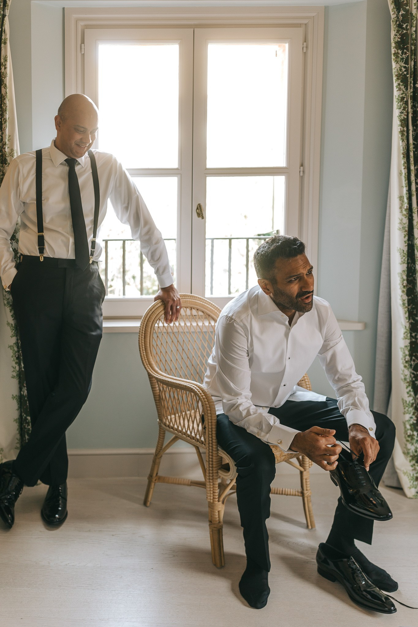 Groom getting ready with a groomsman in their suite before the Mallorca wedding