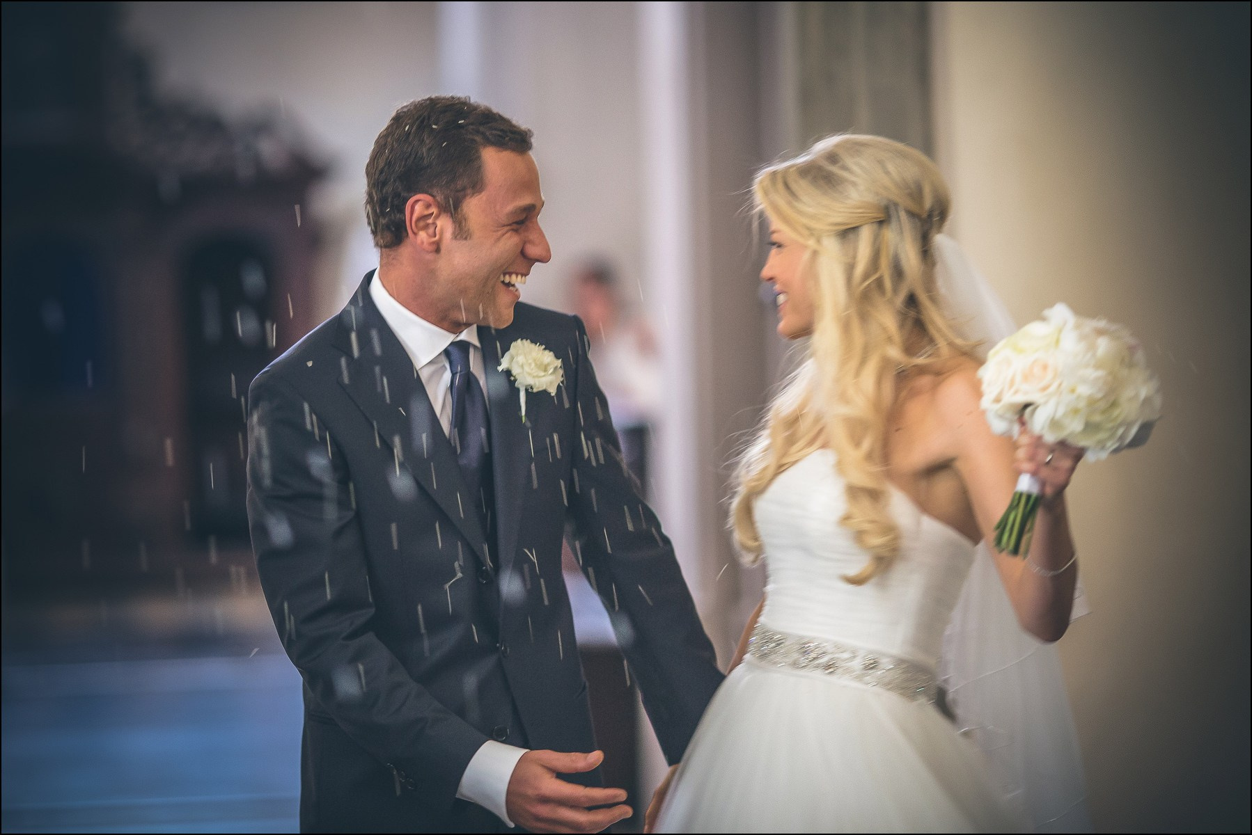 Bride and groom smiling during rice toss celebration Prague