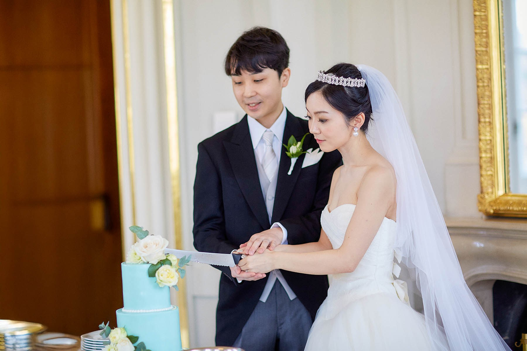 Newlyweds smiling during wedding cake cutting at Belvedere Palace.