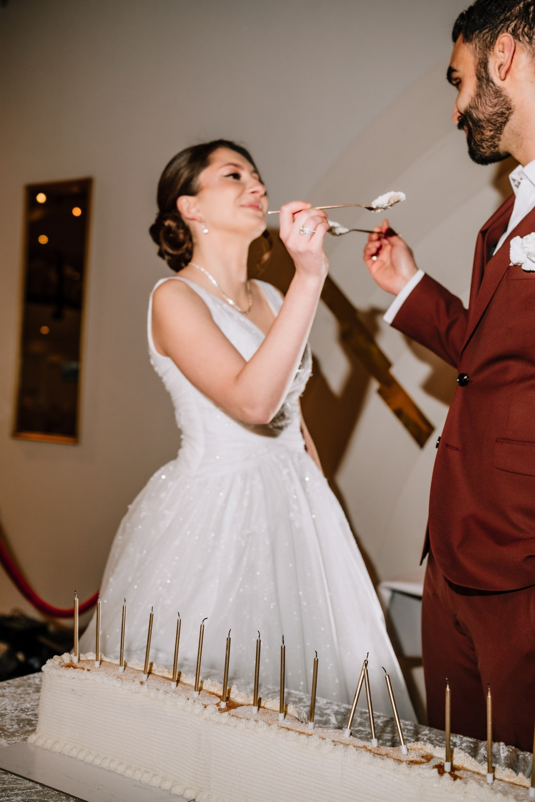 Vanessa und Tahar füttern sich gegenseitig mit Hochzeitstorte im The Eventery – fotografiert von Hochzeitsfotografin Anna Saribekyan