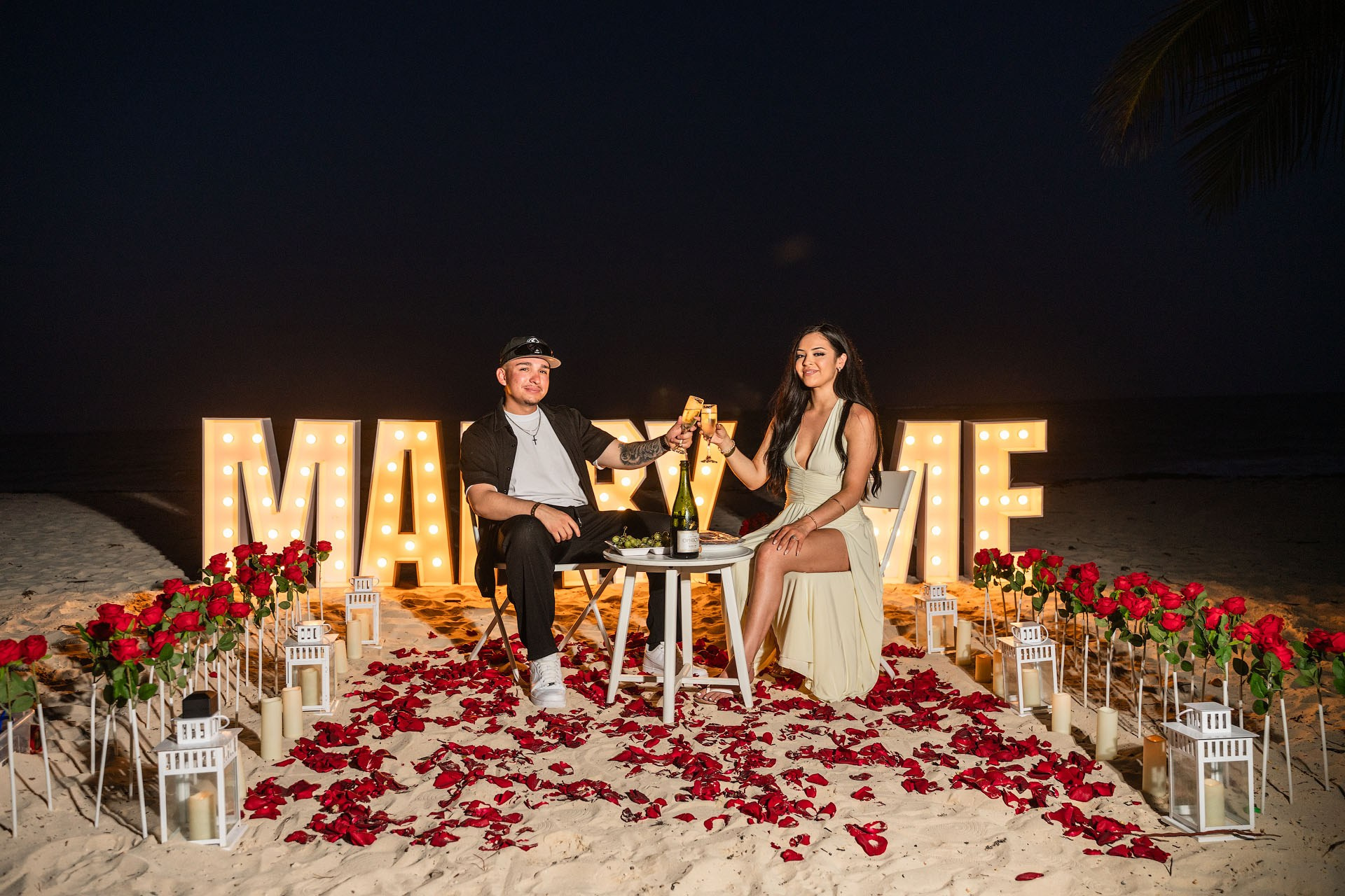 VIP beach proposal in Punta Cana with Marry Me letters, rose pathway, and champagne celebration