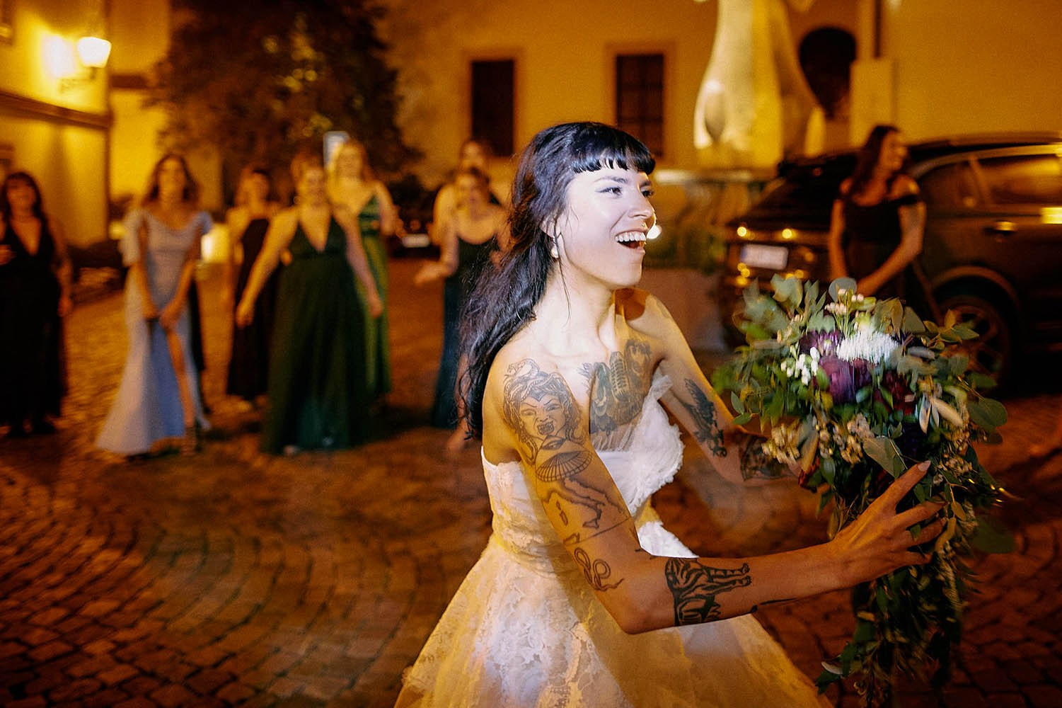 Bride playfully faking bouquet toss to amused crowd.