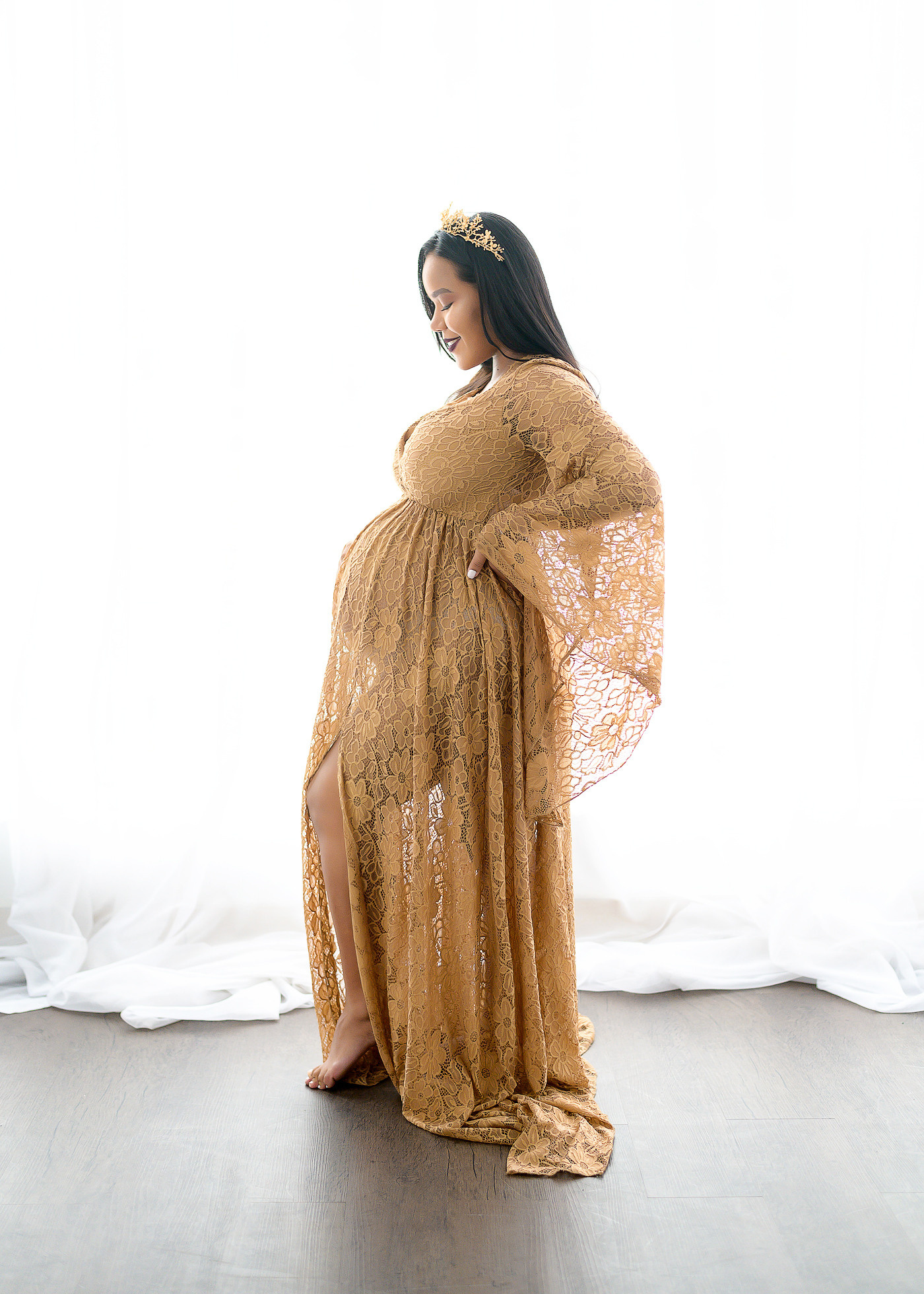 Silueta de una embarazada con un vestido de mostaza en el fondo de la ventana