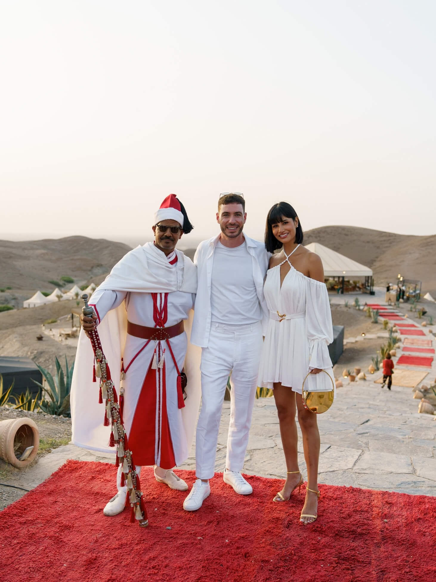 Guests posing on red carpet at destination desert wedding venue, Morocco