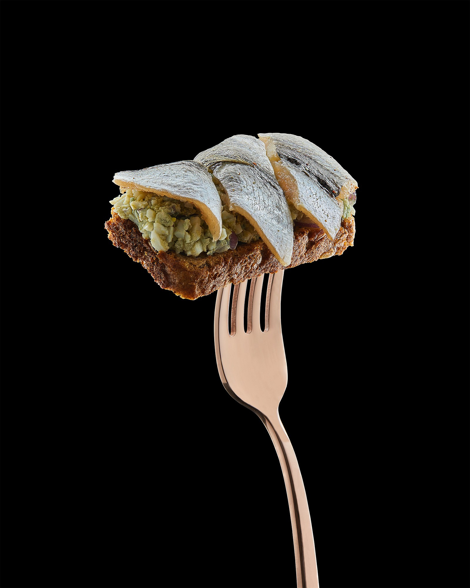 Photographer Roman Djuzev - Sandwich with sprat on a fork, dark background, close-up.