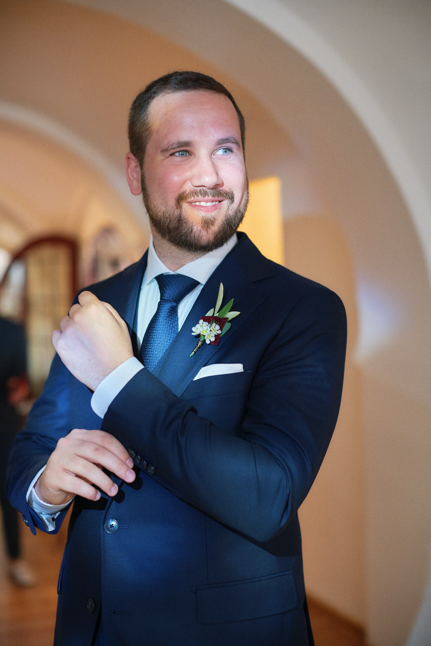 Groom showcasing luxury watch in poised confident portrait.