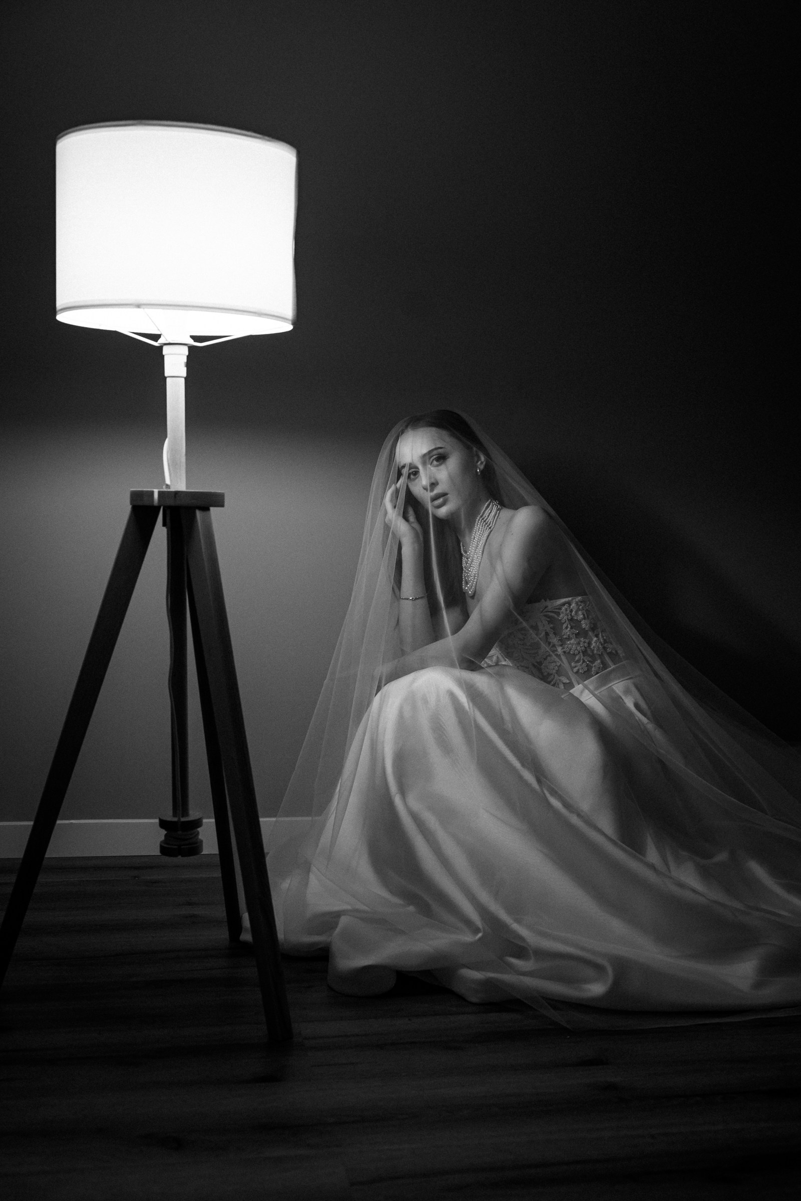 Braut im Lampenlicht, künstlerisches Schwarzweiß‑Portrait.