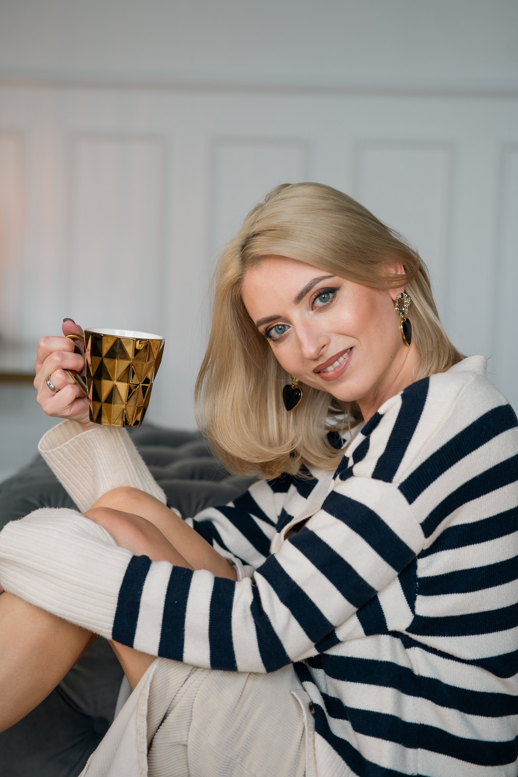 Blonde woman smiling with a cup of coffee, Riga photographer