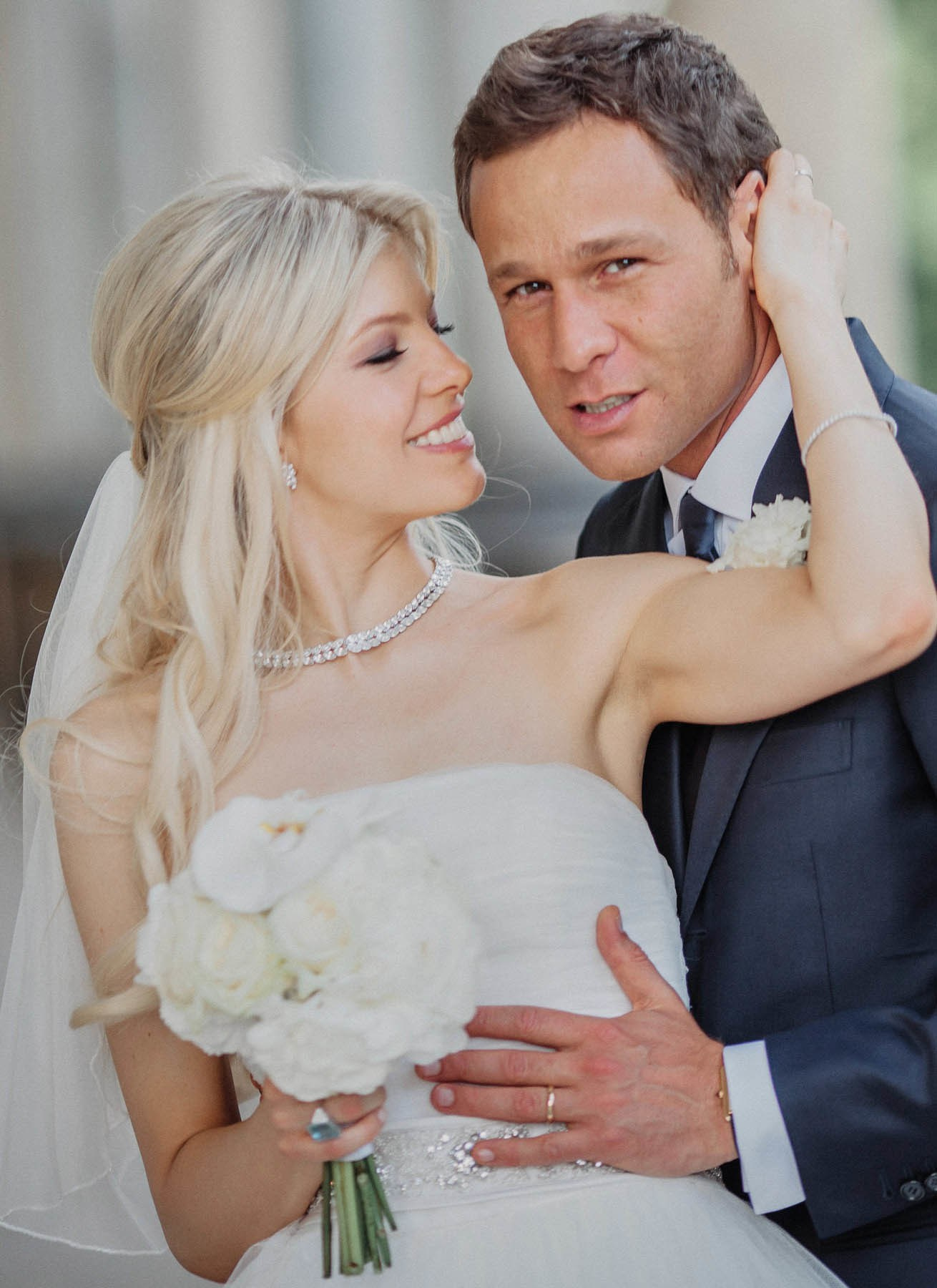 Groom embracing bride from behind during Prague couple portraits