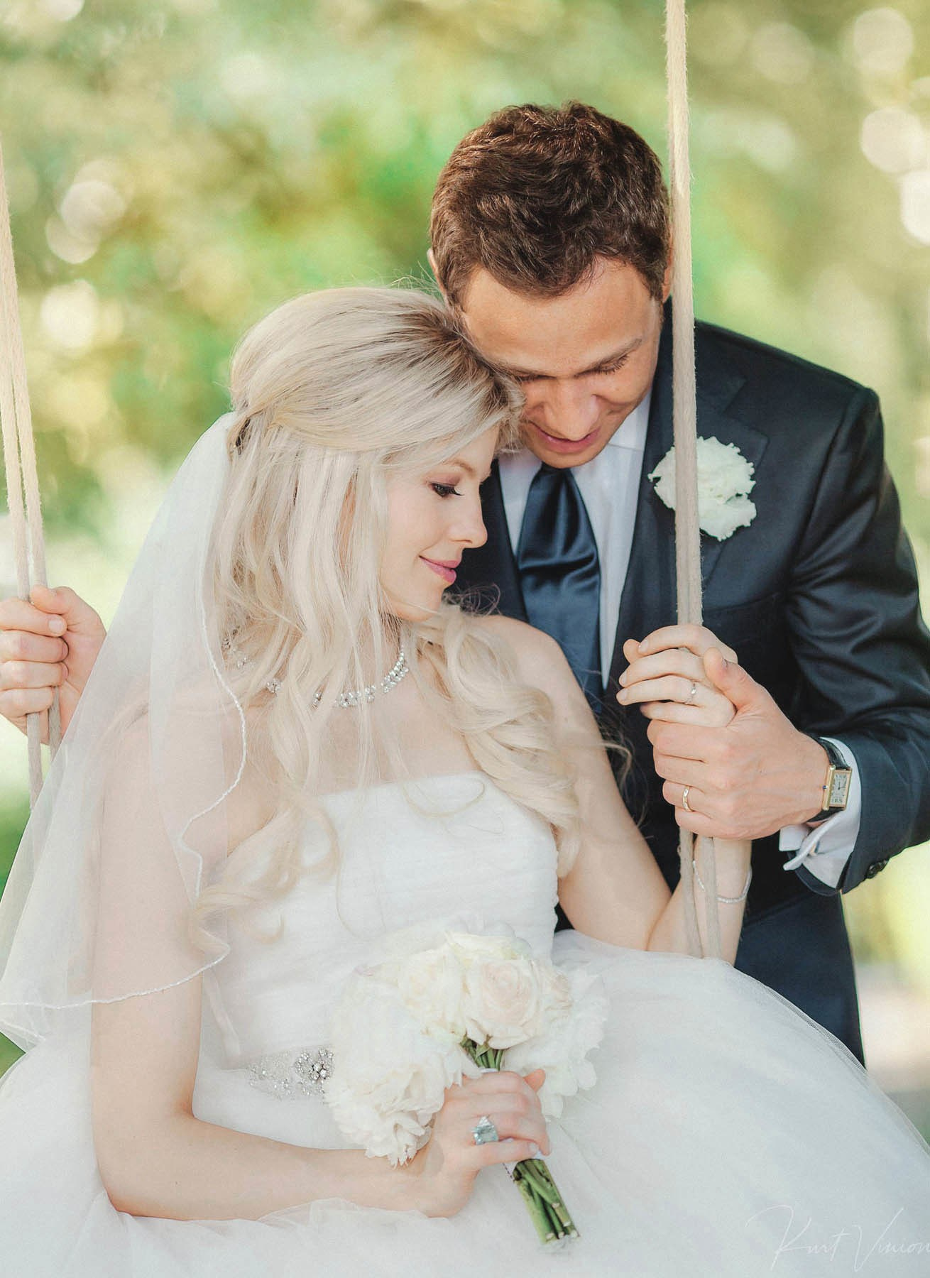 Tender embrace on garden swing during Prague wedding portraits