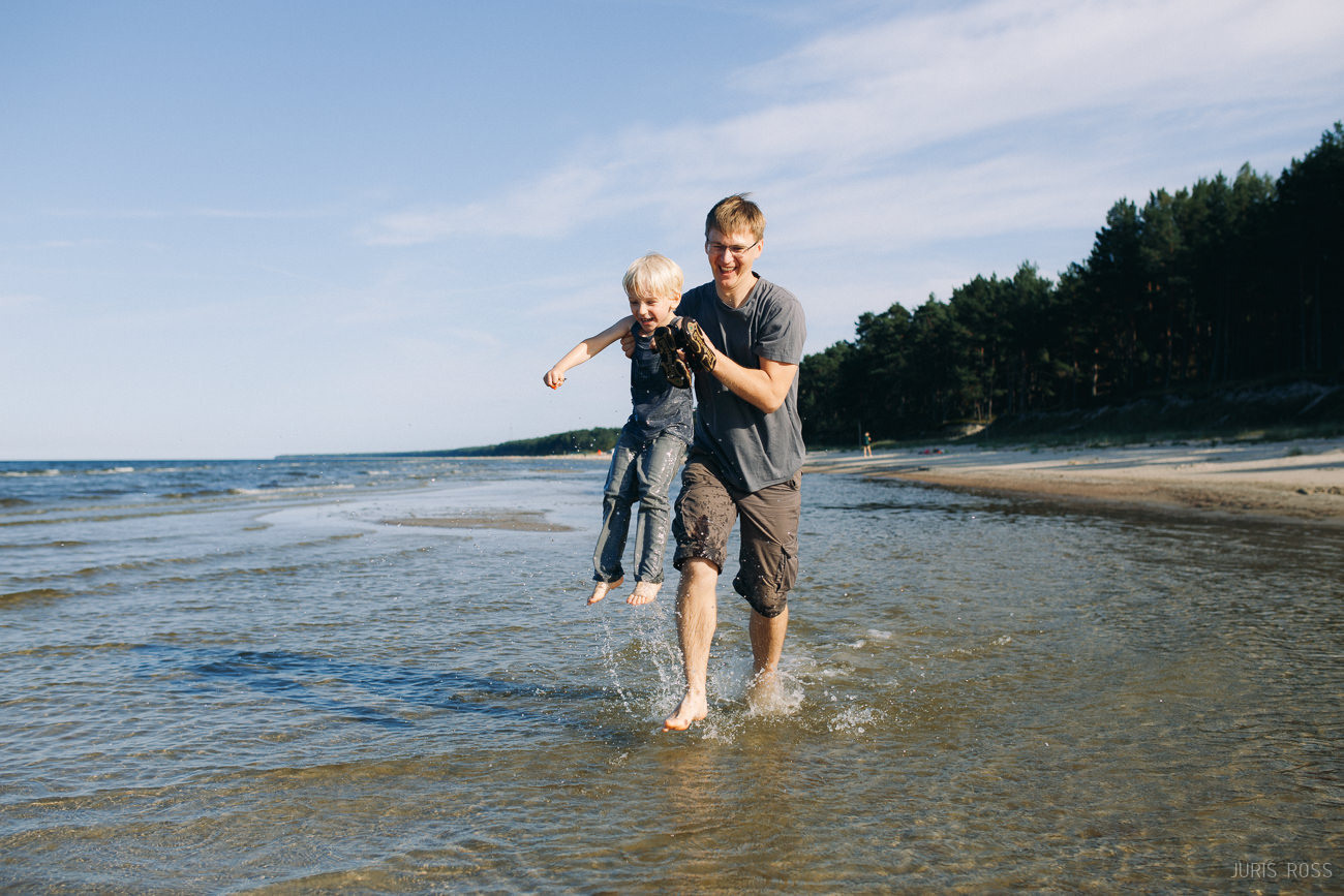 Ģimenes fotosesija pie jūras ar slapjām biksēm