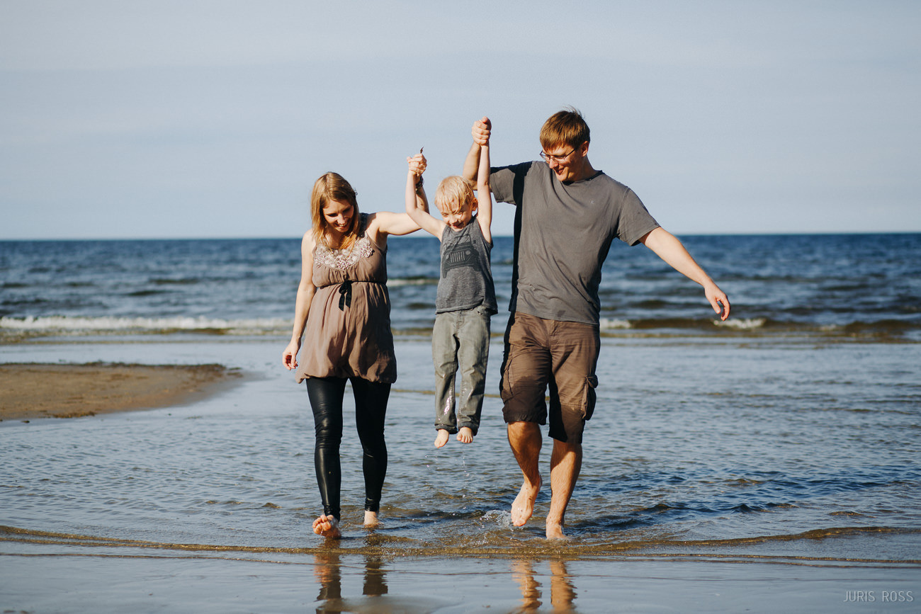 Ģimenes fotosesija pie jūras ar slapjām biksēm