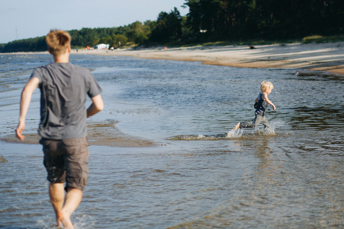 Ģimenes fotosesija pie jūras ar slapjām biksēm