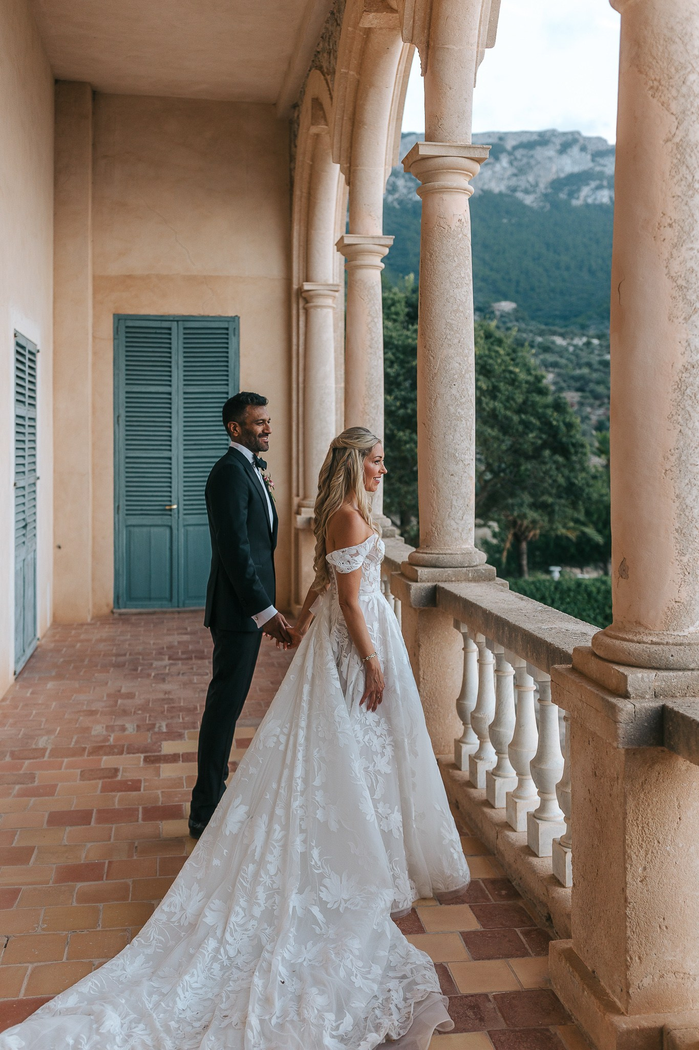 Bride and groom walking hand in hand along the balcony at their Son Marroig destination wedding