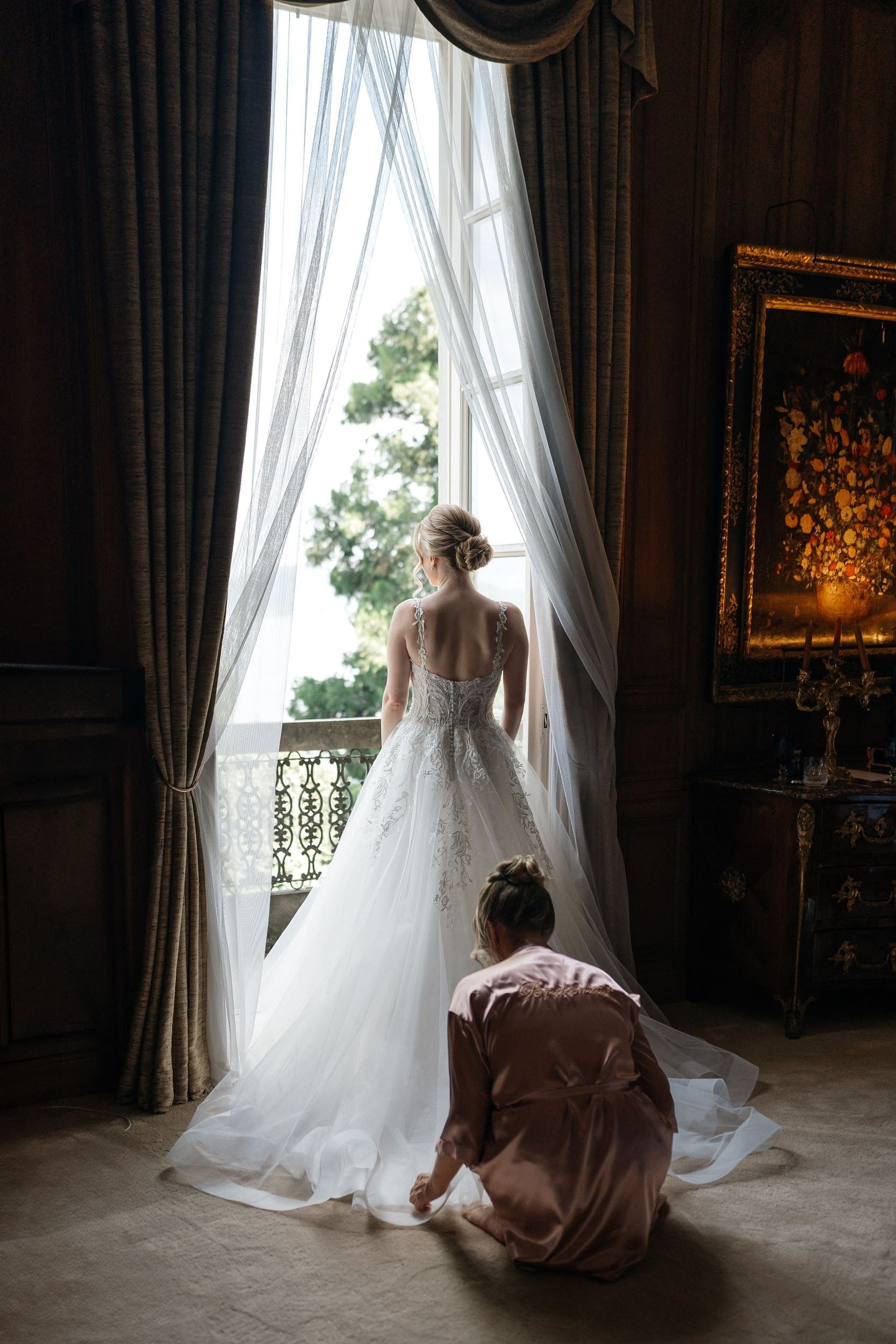 bridesmaid helping bride with the dress
