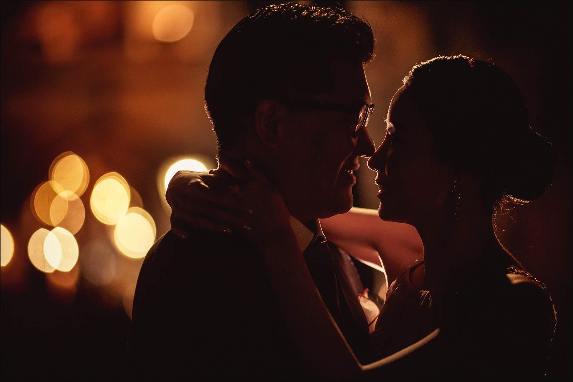Cedric Son embraces Catherine silhouette Charles Bridge nighttime Prague wedding portrait.