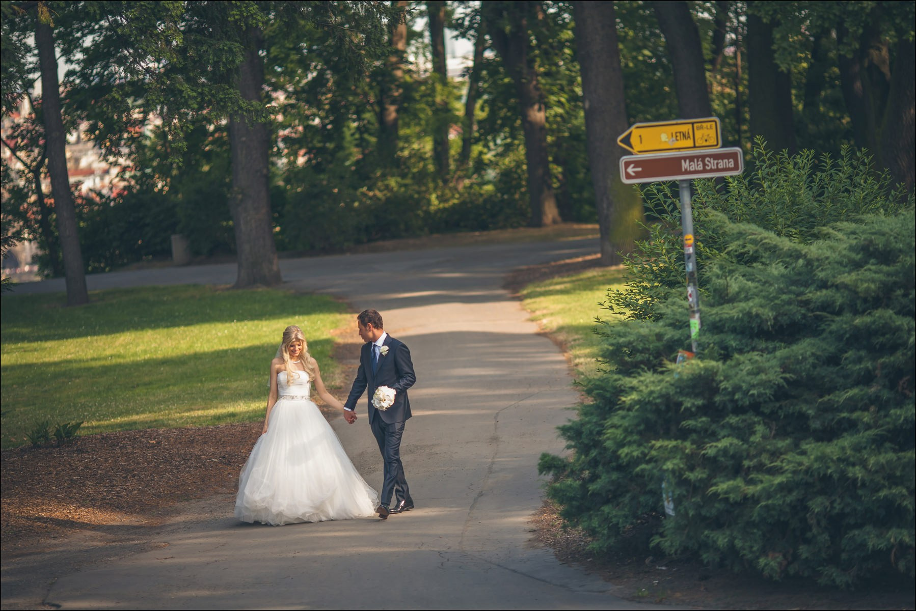 Newlyweds strolling through gardens of Queen Anne's Summer Palace Prague