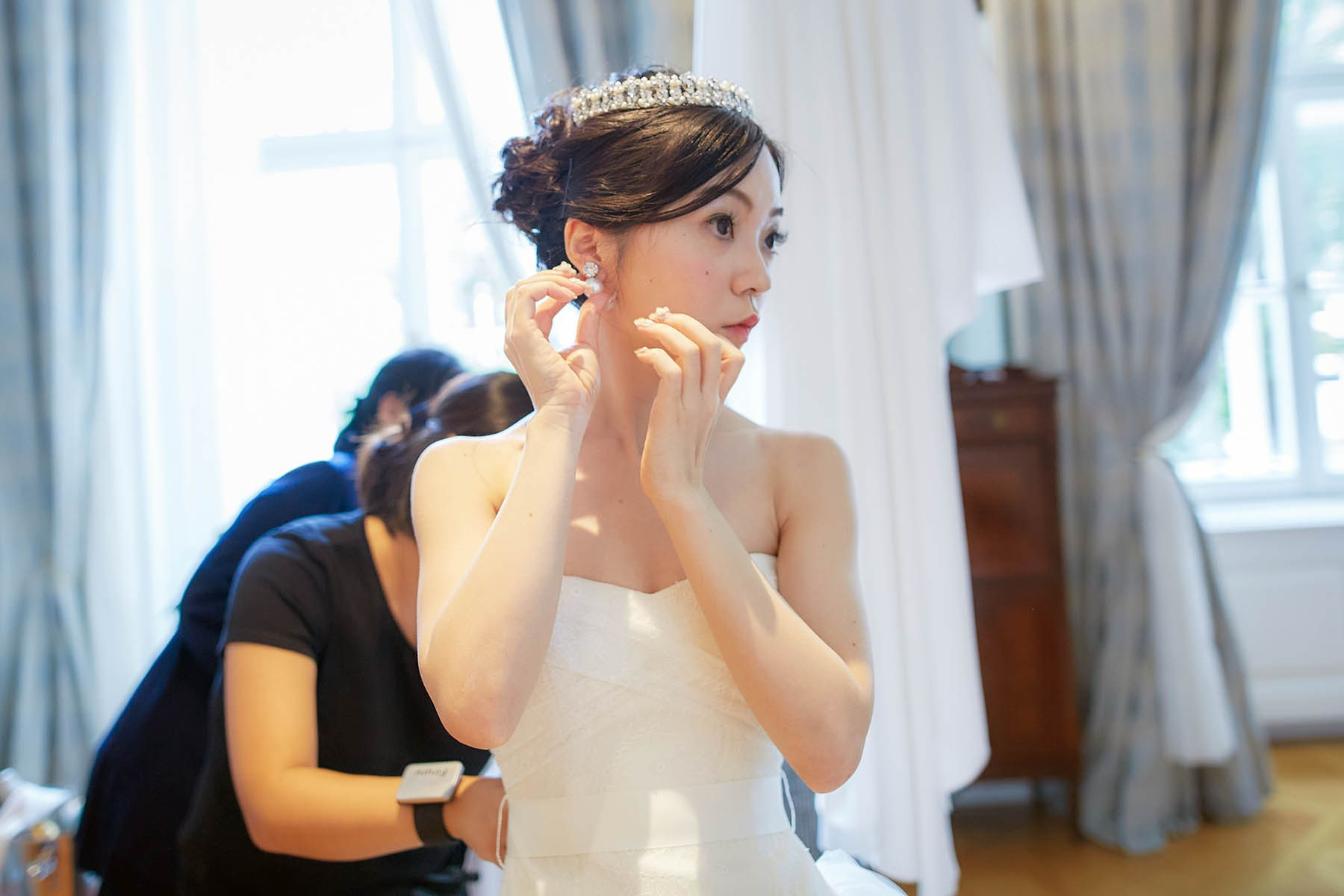 The final touches of putting on her earrings.