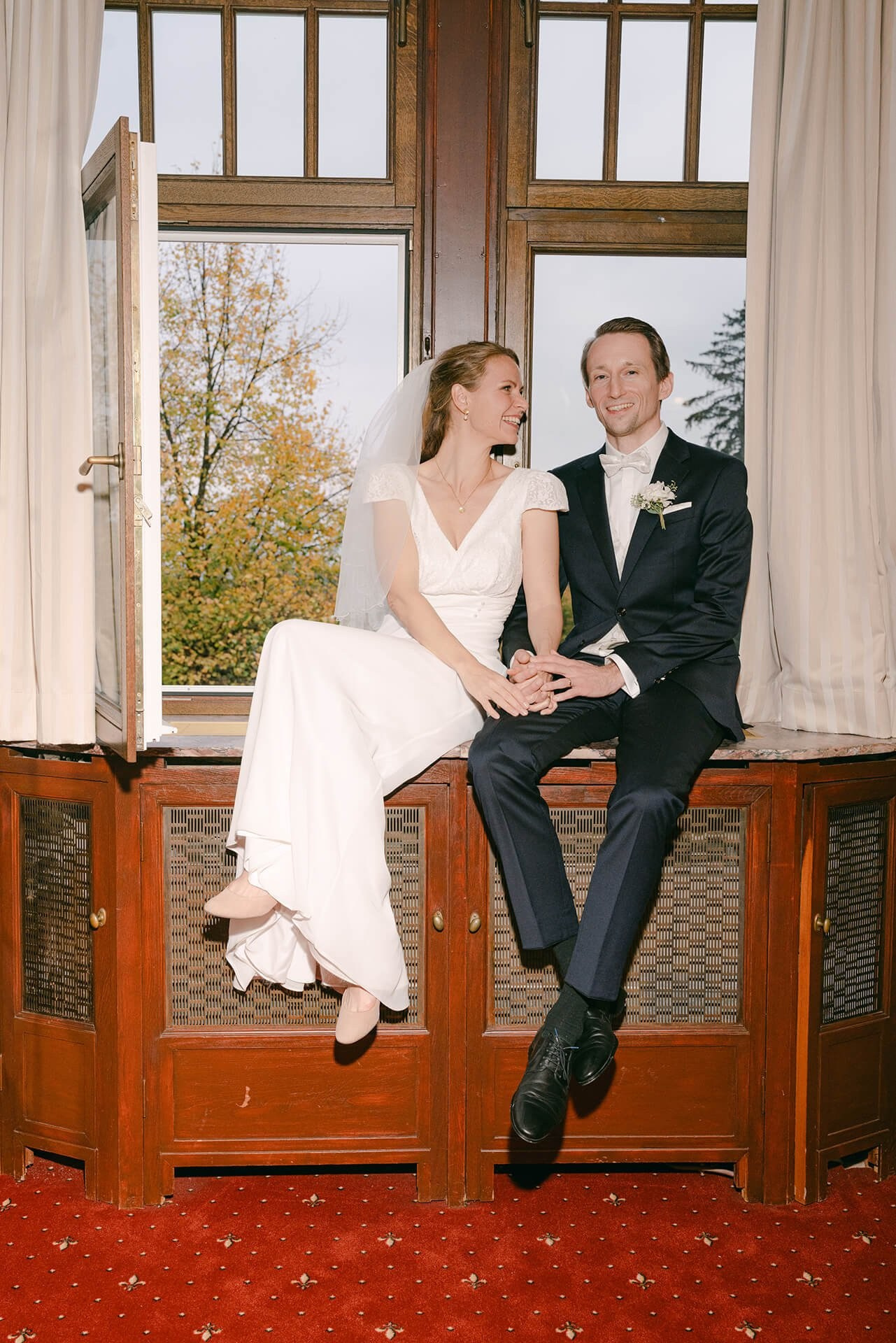 Couple seated by window, editorial wedding portrait at Falkenstein Grand