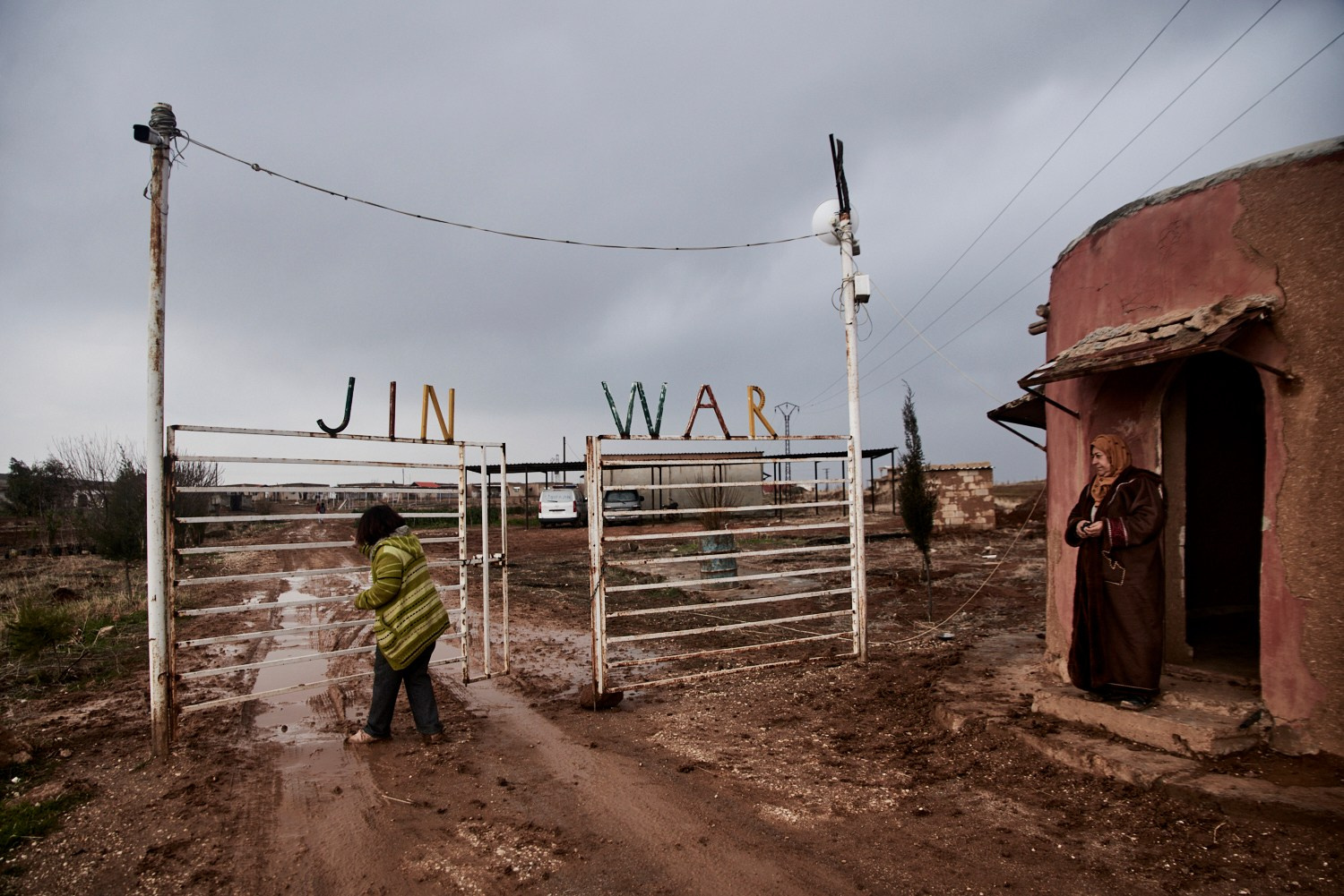 Jinwar, 12 février 2025 - Une gardienne ouvre la grille à l'entrée du village de Jinwar, réservé aux femmes et dans lequel vivent seize familles. Les habitantes ont construit elles-mêmes ce havre de sécurité, pour se protéger des violences de la guerre et des hommes.