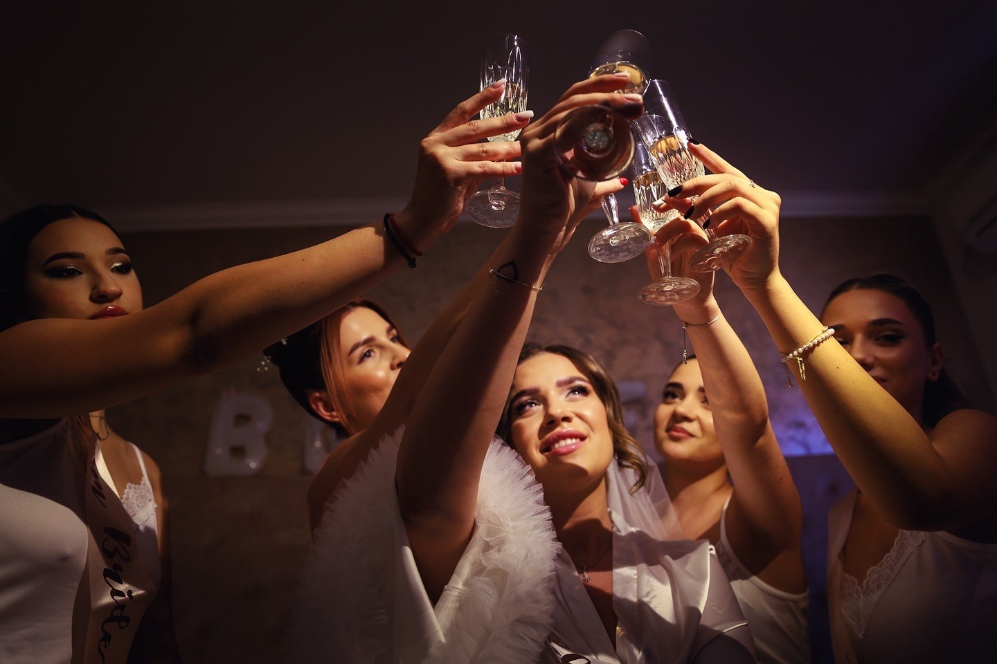 Invitați ridicând paharele în toast la petrecerea de nuntă