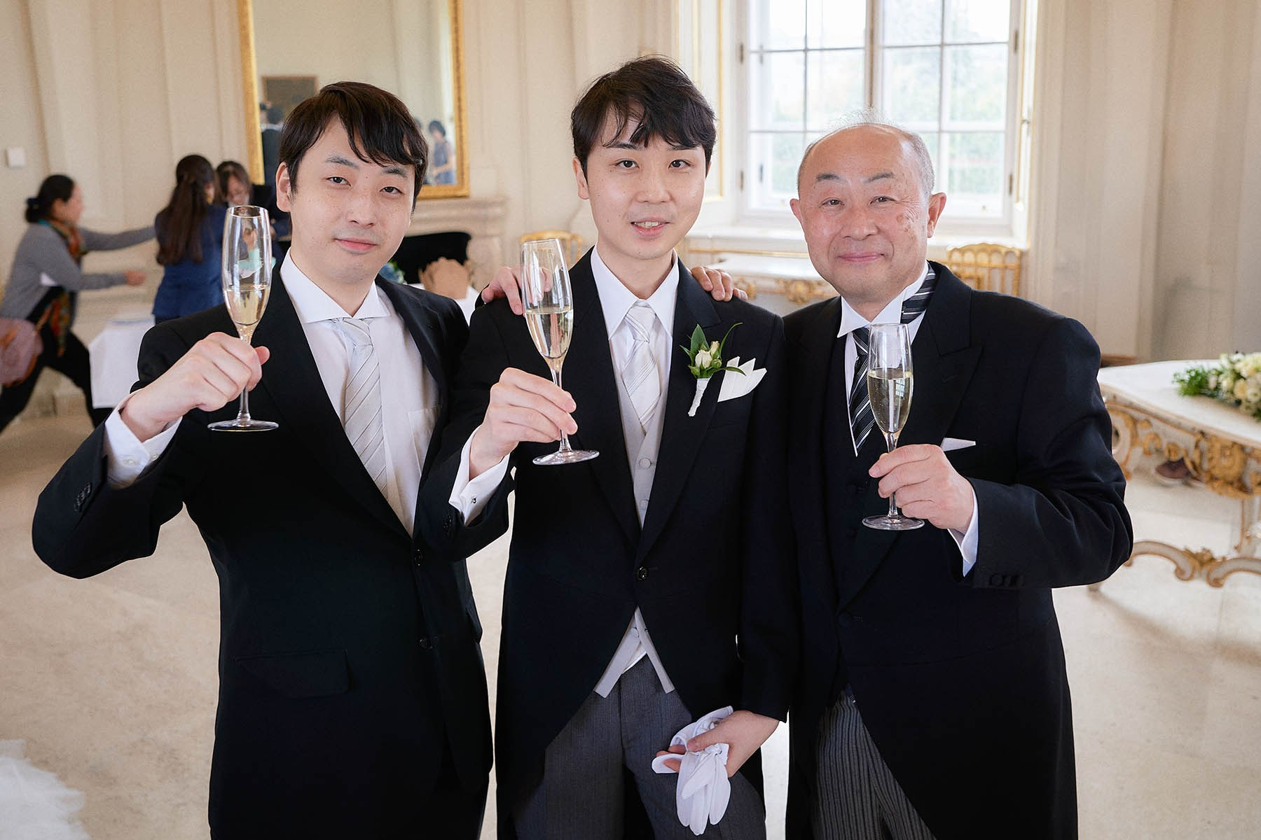 Groom with father and brother toasting with champagne Vienna.