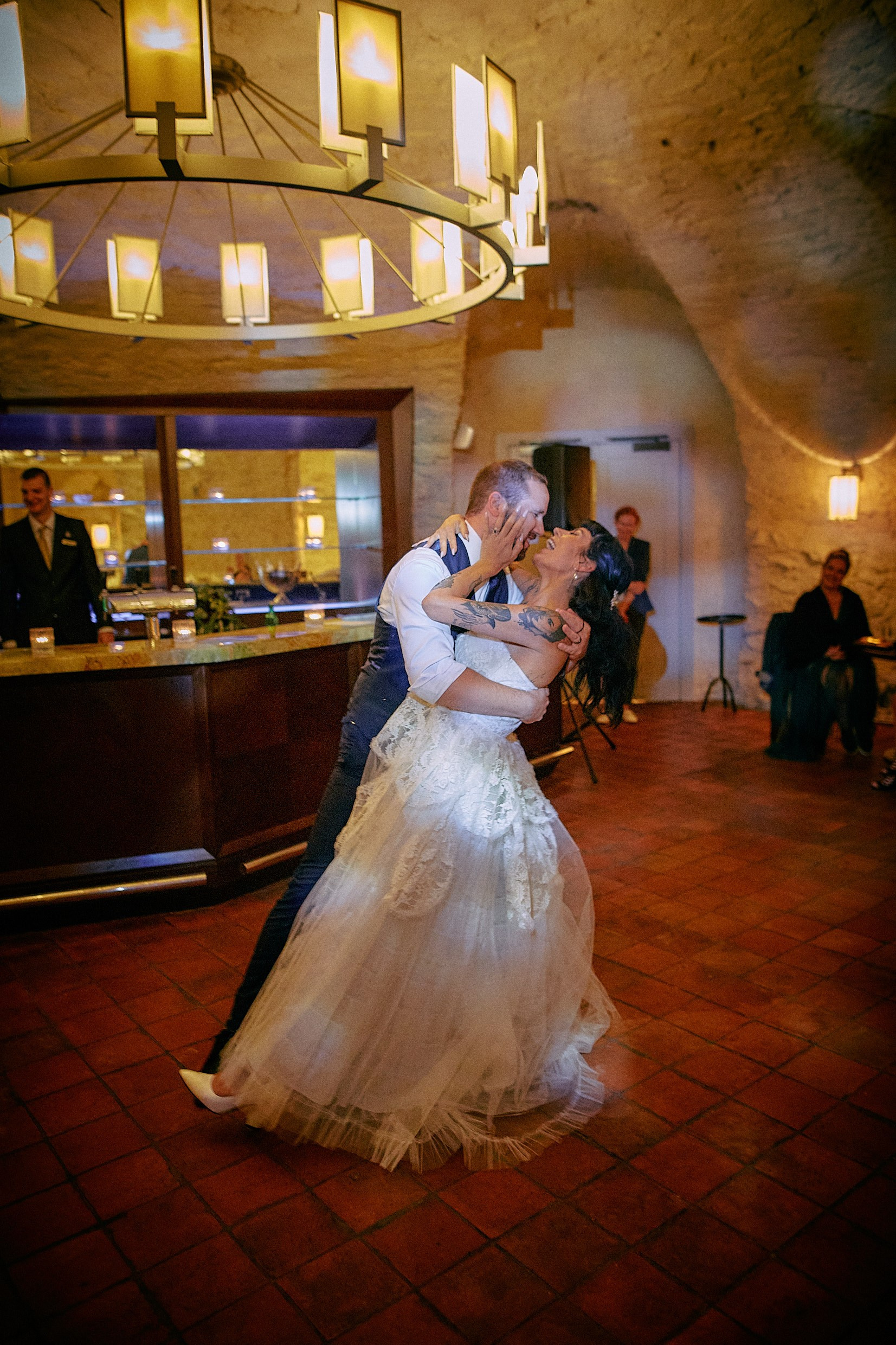Bride and groom sharing sweet kiss during wedding reception dance.