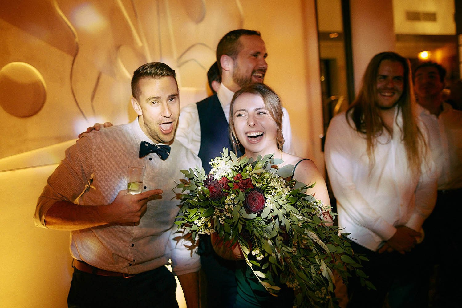 Bouquet catcher laughing with partner, hinting next wedding.